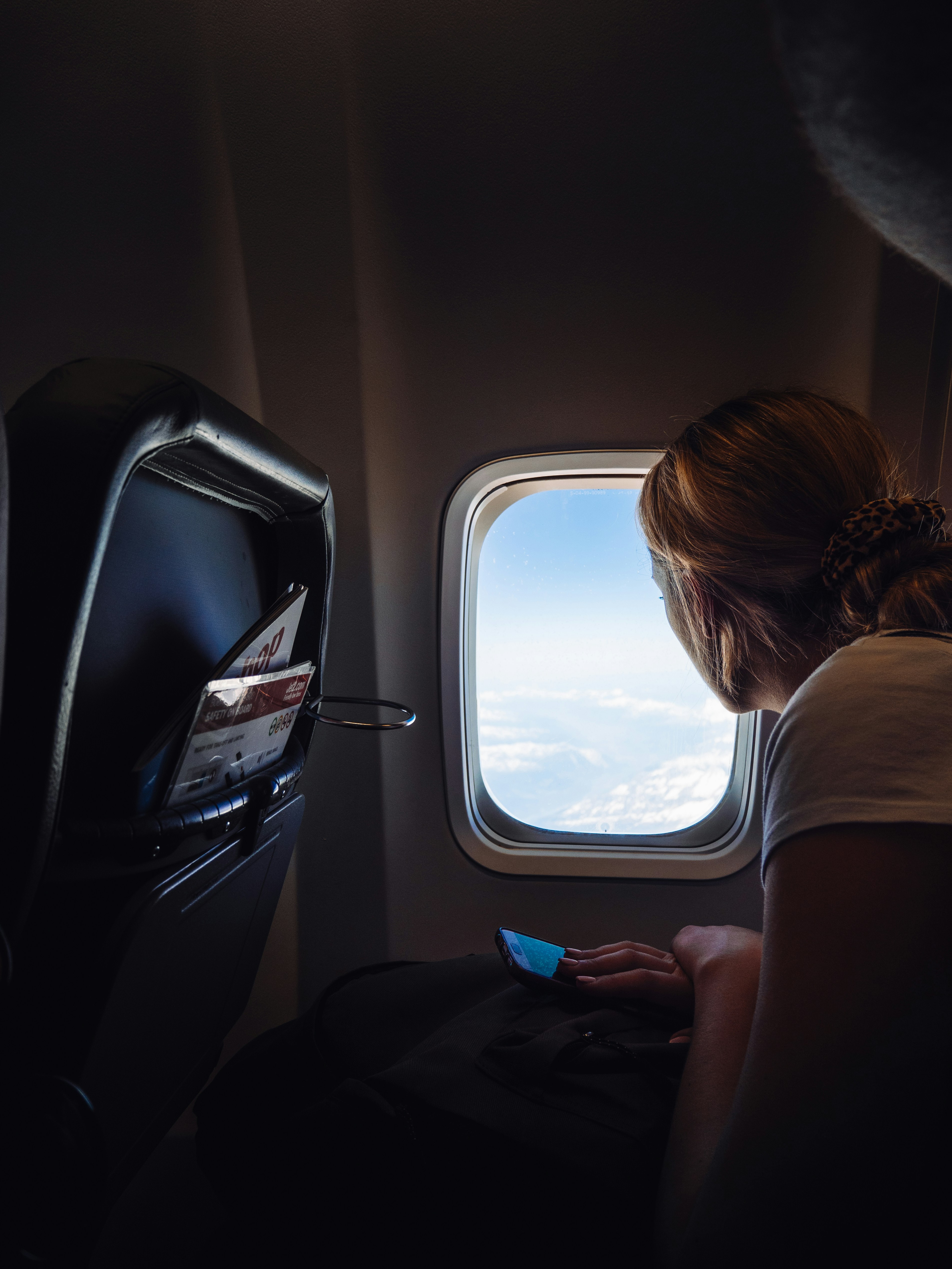 Une femme assise dans un avion et regardant dehors | Source : Unsplash
