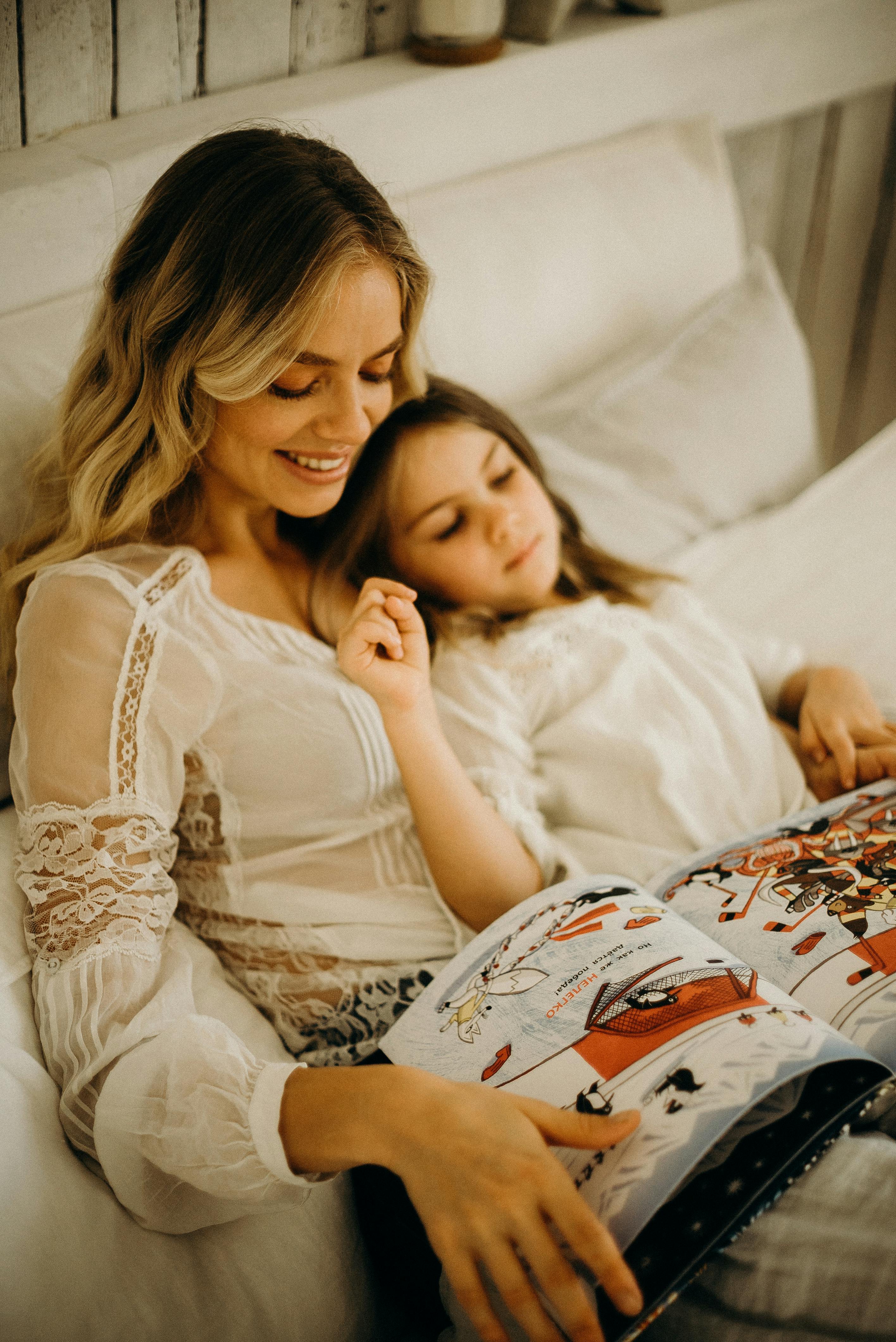 A mom and daughter laying in bed | Source: Pexels