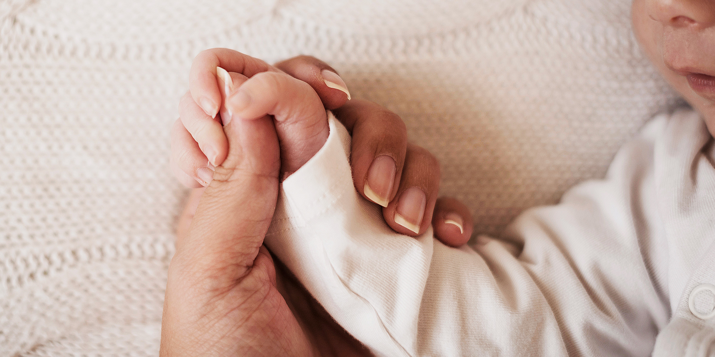 A woman holding a baby's hand | Source: Freepik