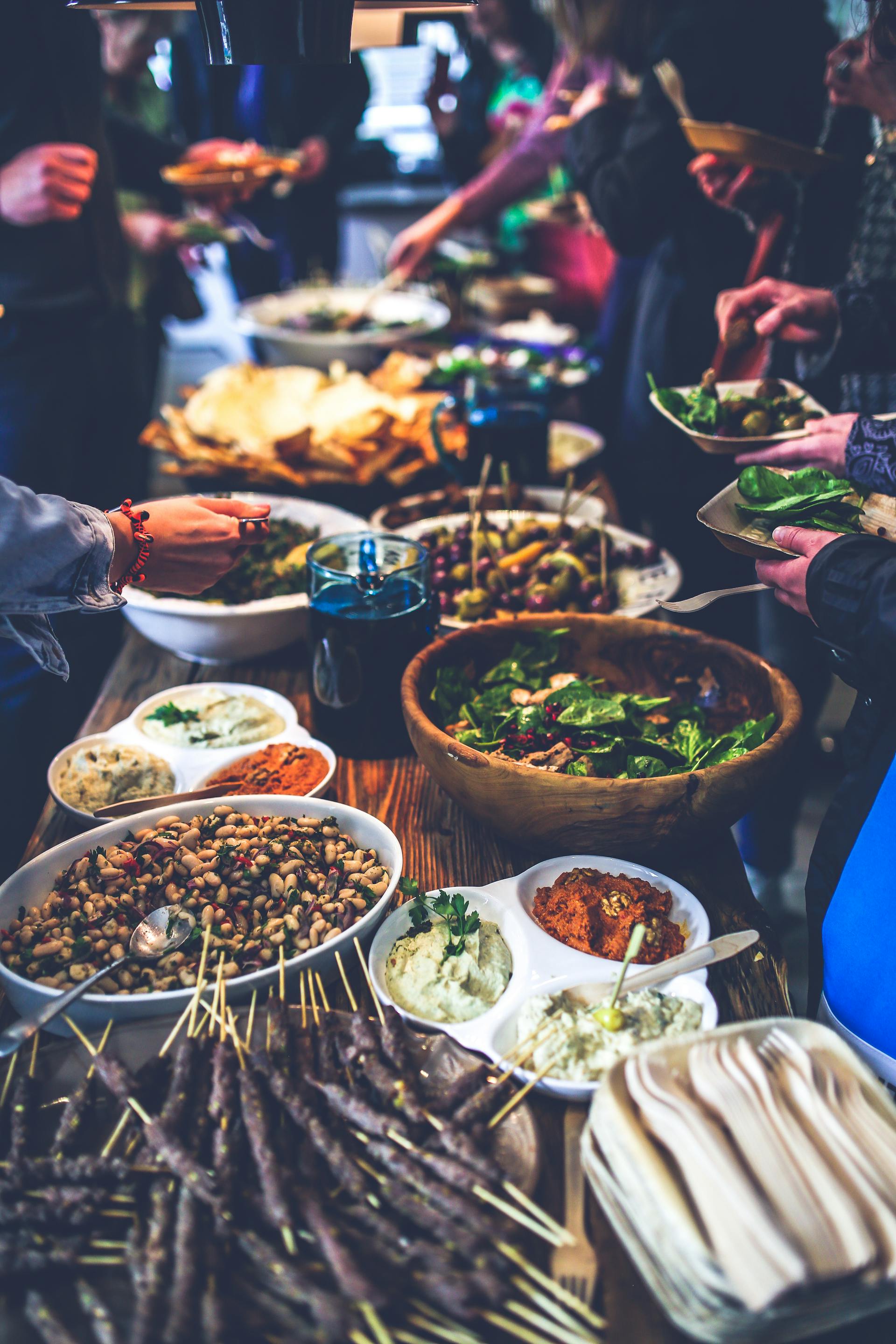 People dishing up food from a buffet | Source: Pexels