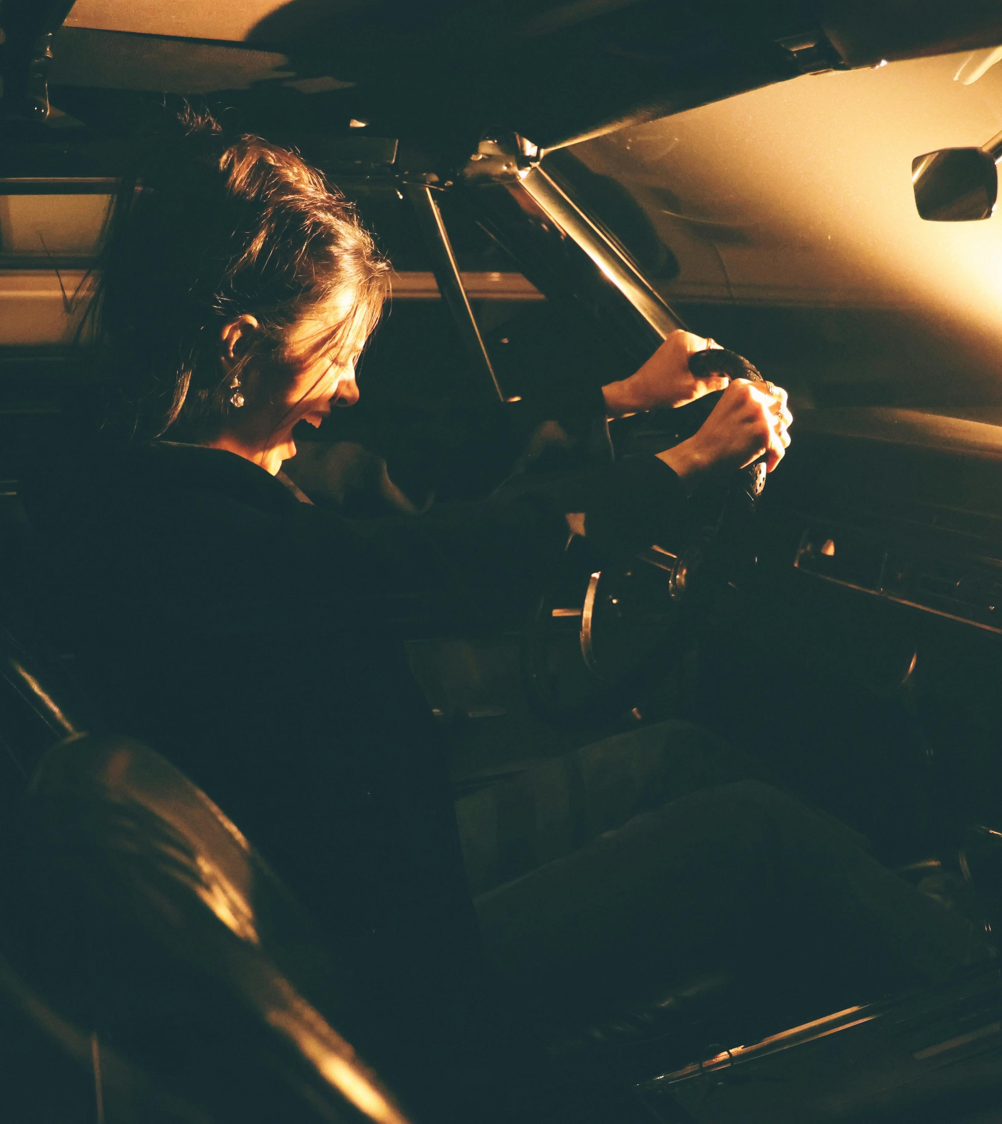 A tired woman driving at night | Source: Pexels
