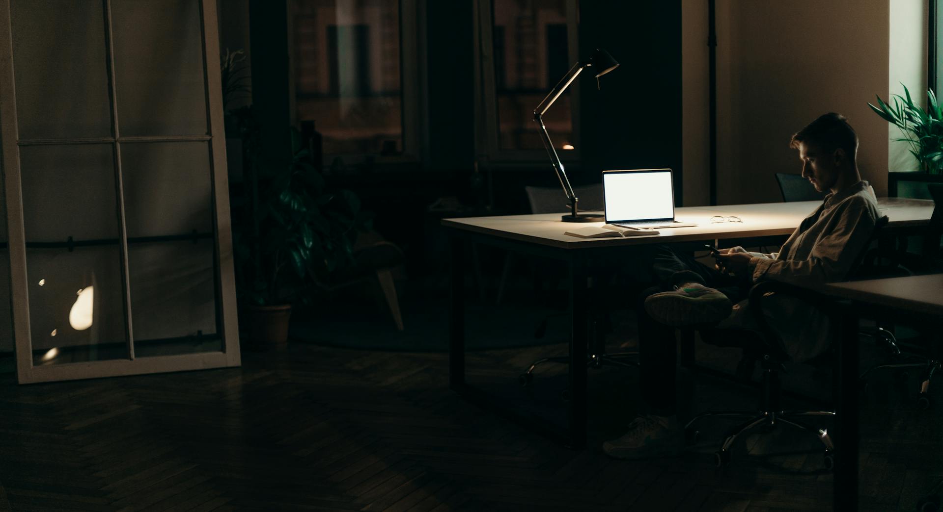 A man sitting in his office at night | Source: Pexels