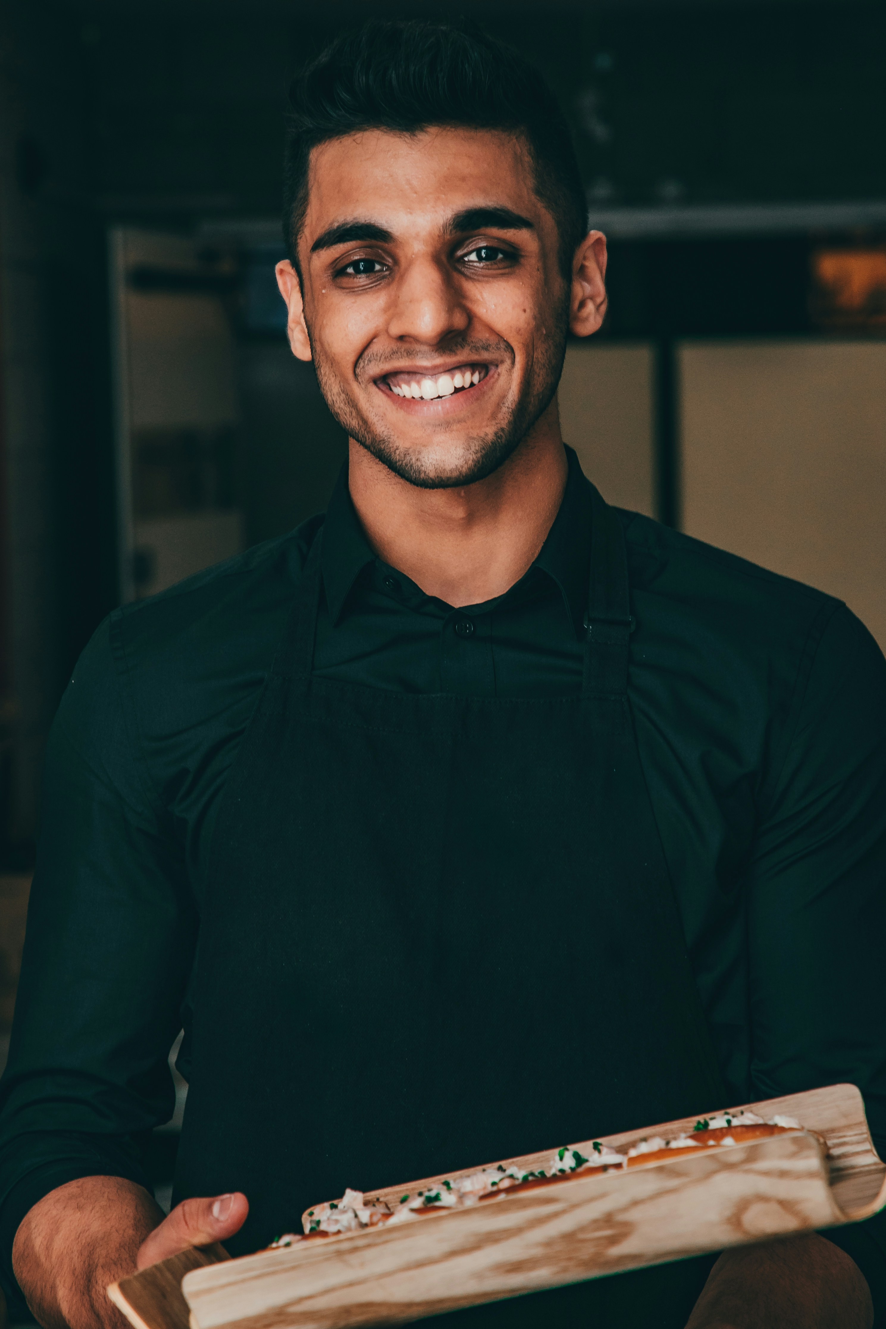 A young and smiling waiter | Source: Unsplash