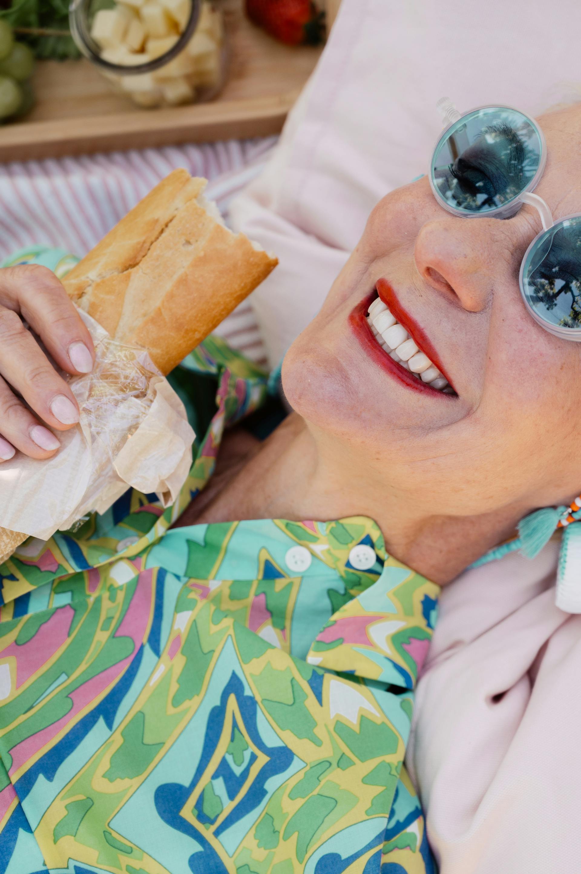 A close-up shot of a senior woman lying down while holding a burger | Source: Pexels