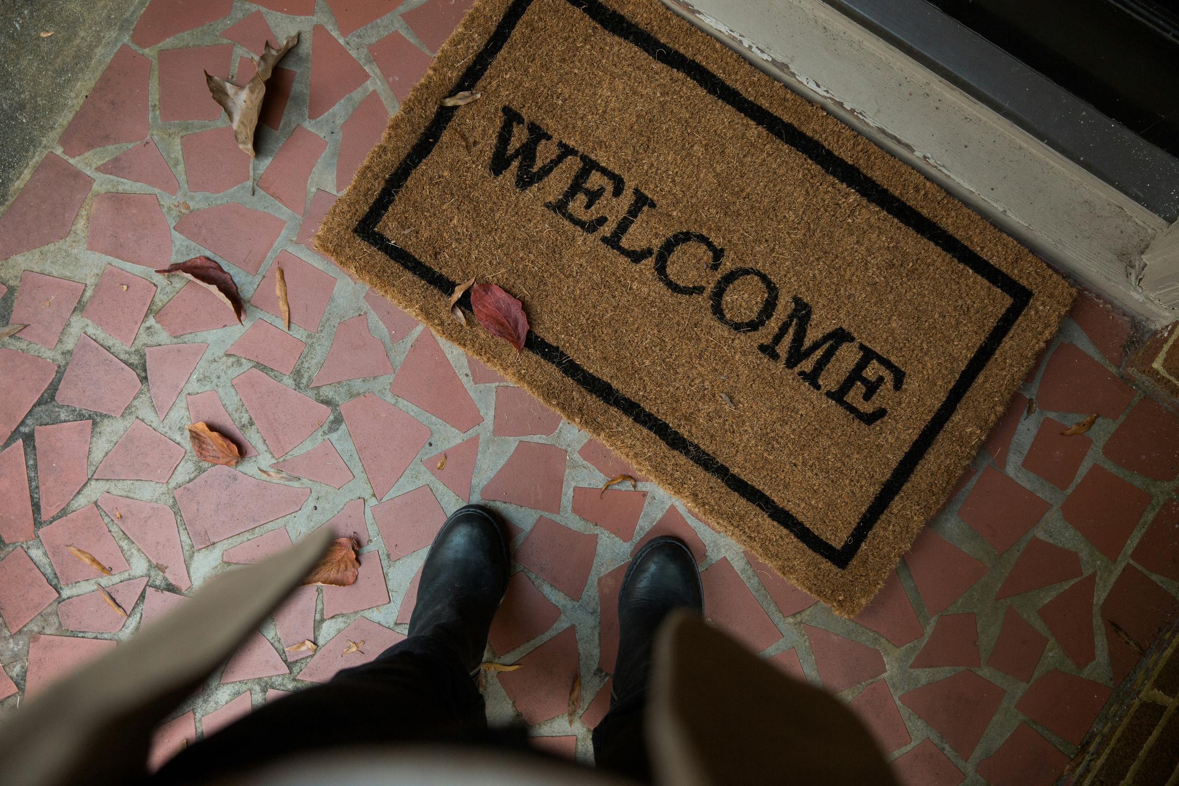 A person standing in front of a welcome mat | Source: Unsplash