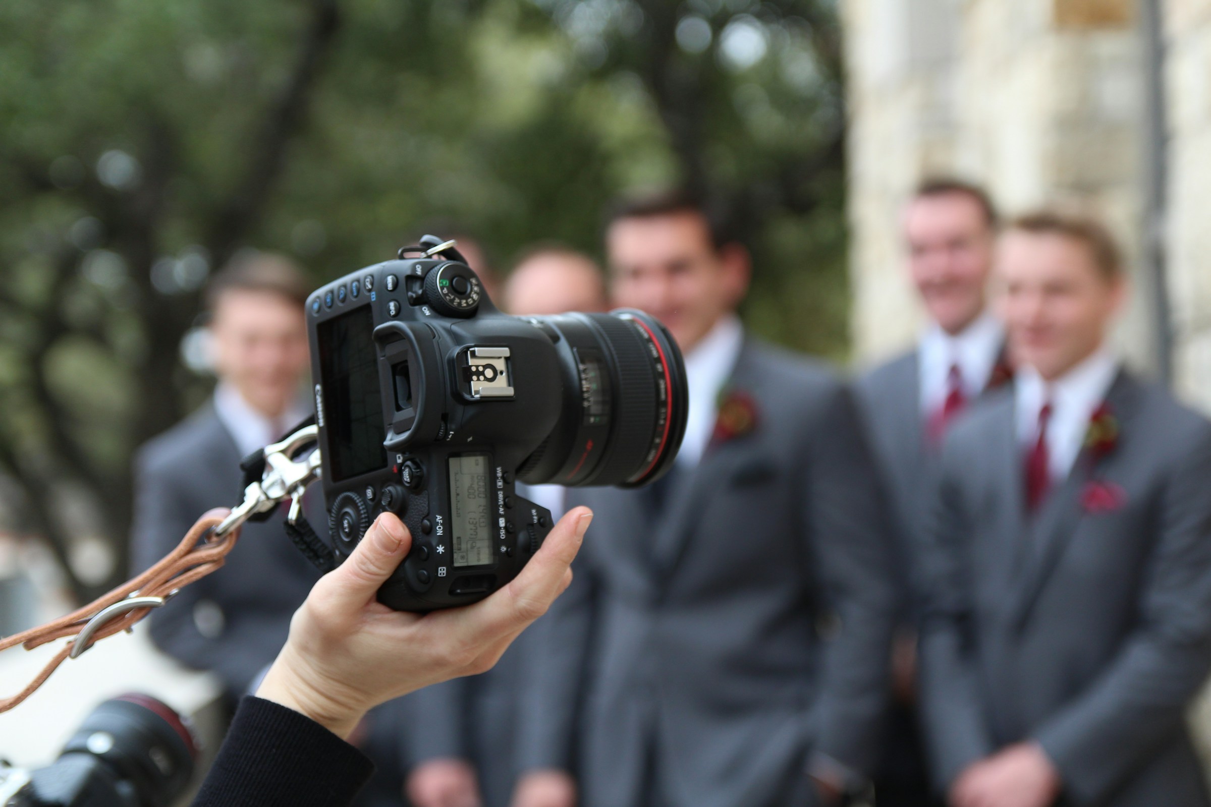 Groomsmen taking photos with a wedding photographer | Source: Unsplash