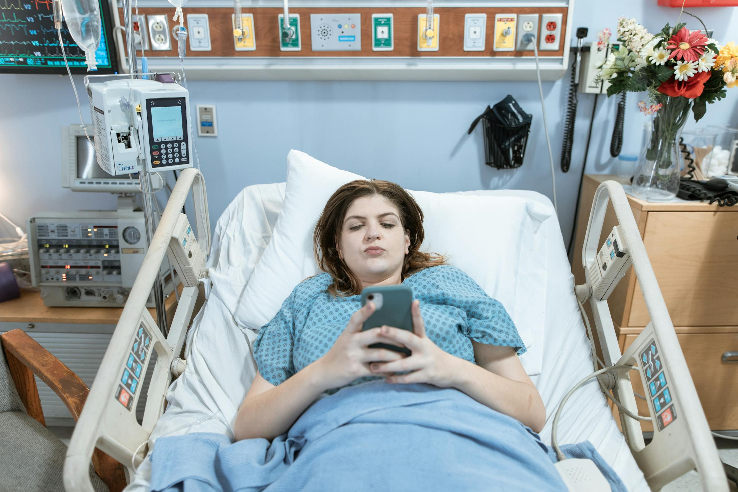 A woman upset while using her phone in a hospital bed | Source: Pexels