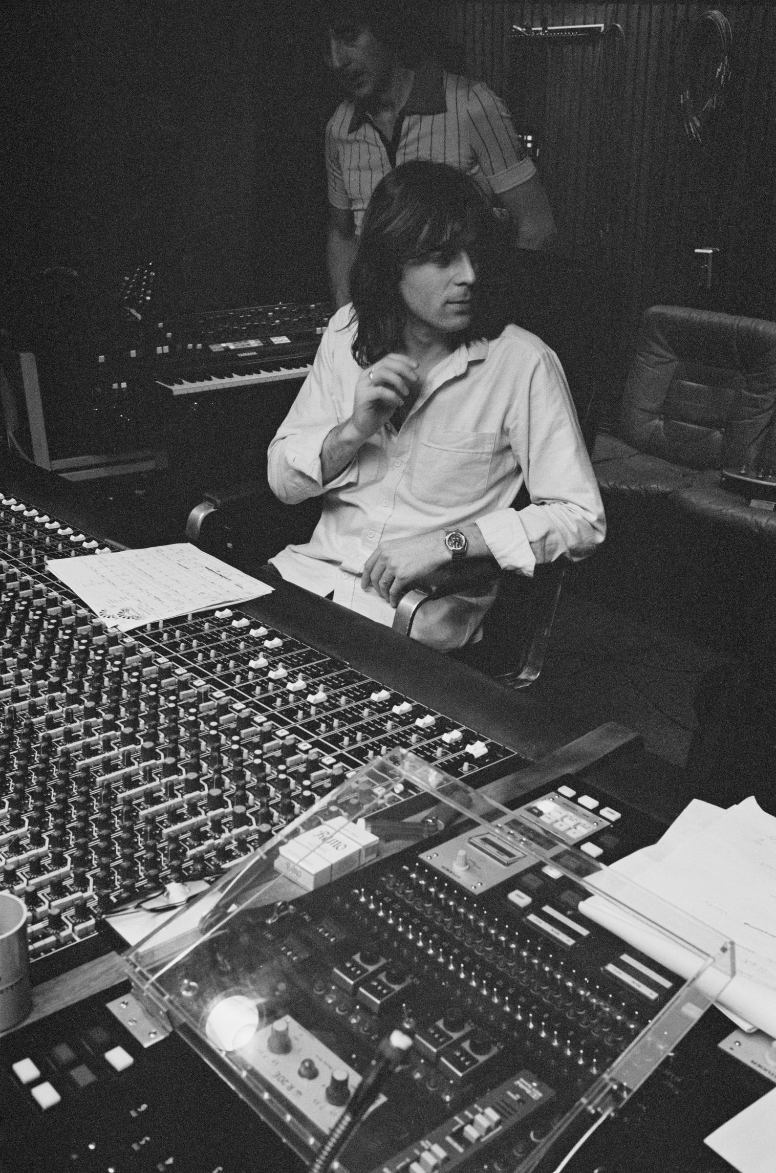 Jeff Lynne of British rock group Electric Light Orchestra, also known as ELO, in the background, behind producer Reinhold Mack, in a studio in Munich, Germany, circa March/April 1979. | Source: Getty Images