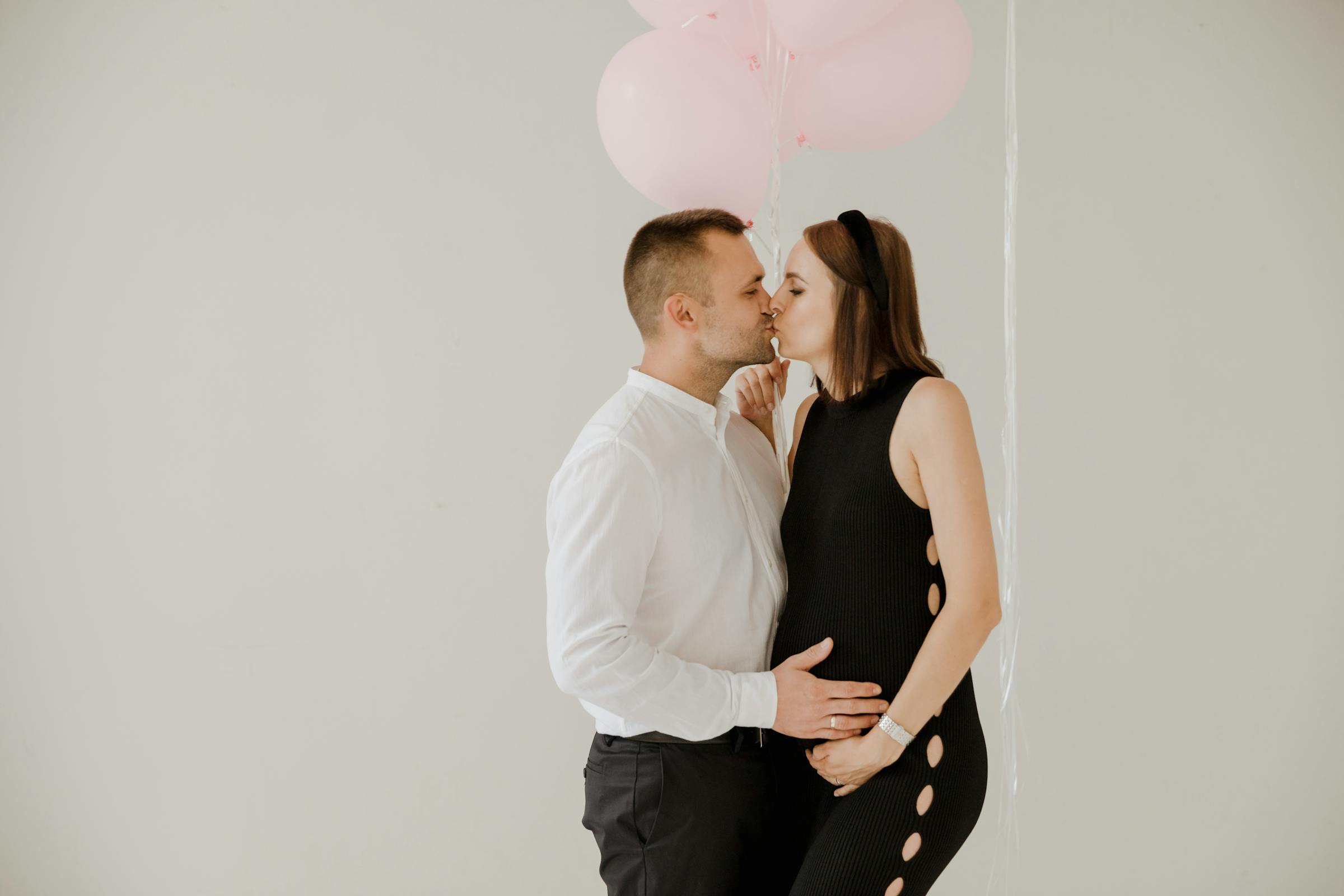 A pregnant couple kissing | Source: Pexels