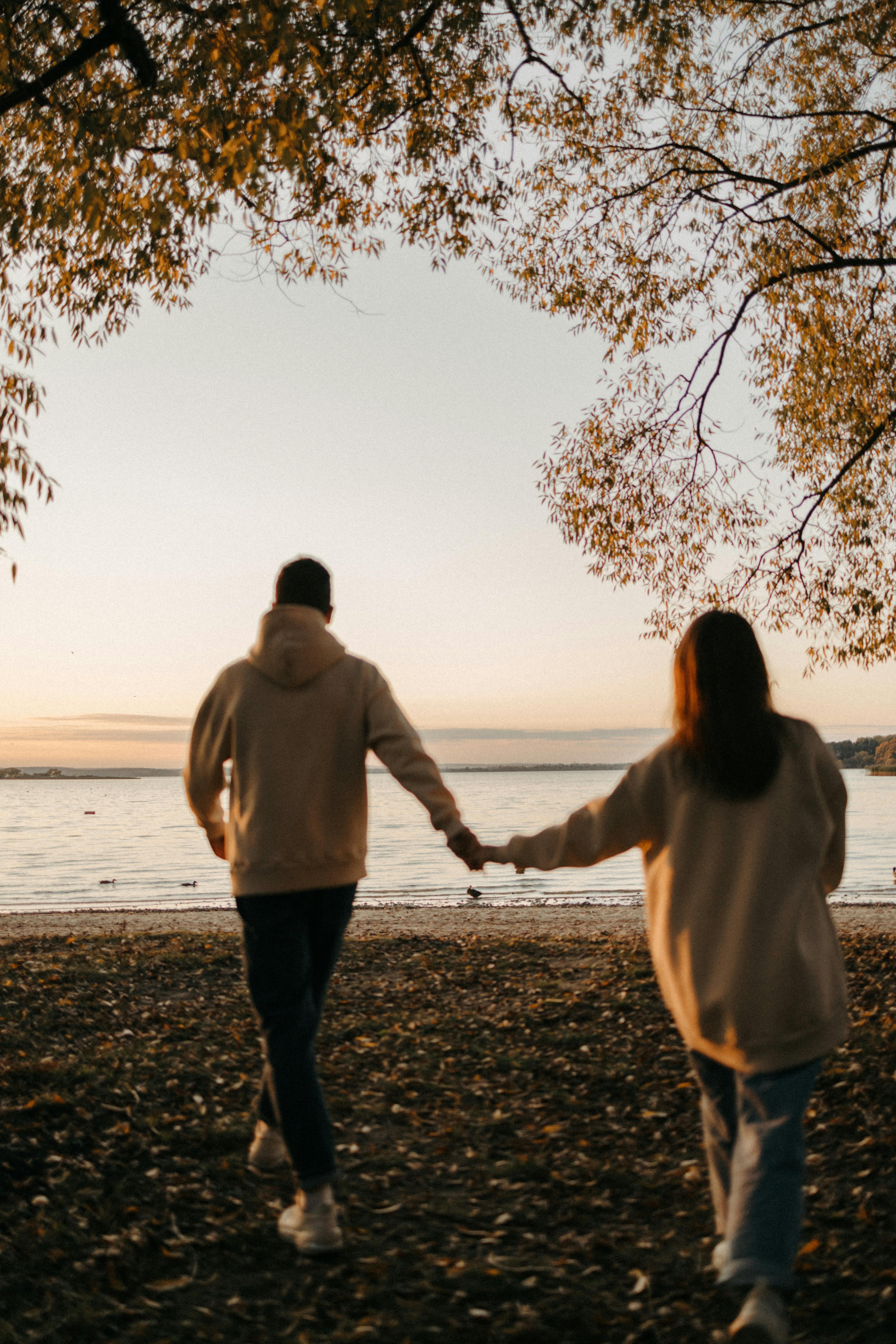 A couple walking by the water at sunset | Source: Pexels