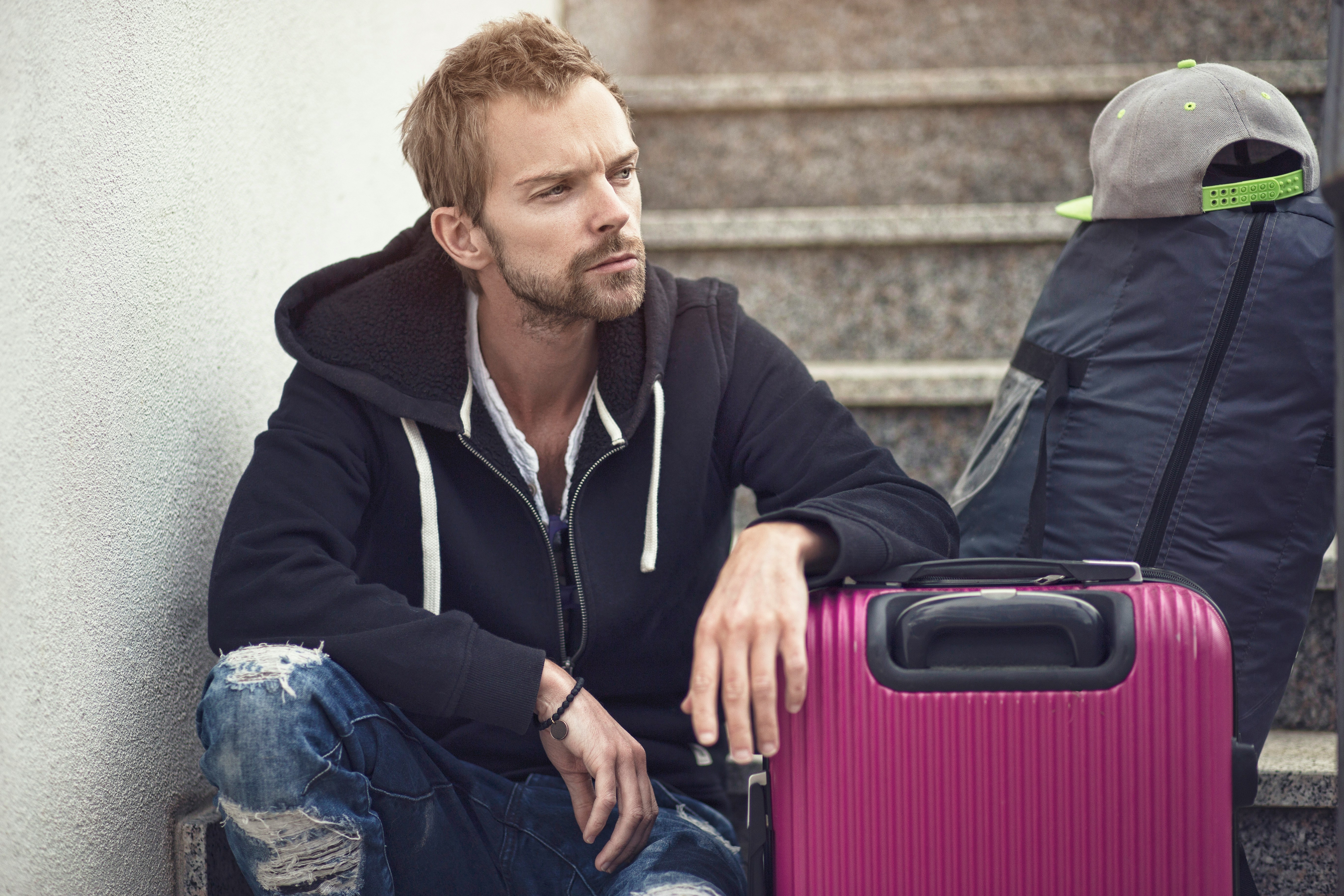 A man sitting with luggage | Source: Unsplash