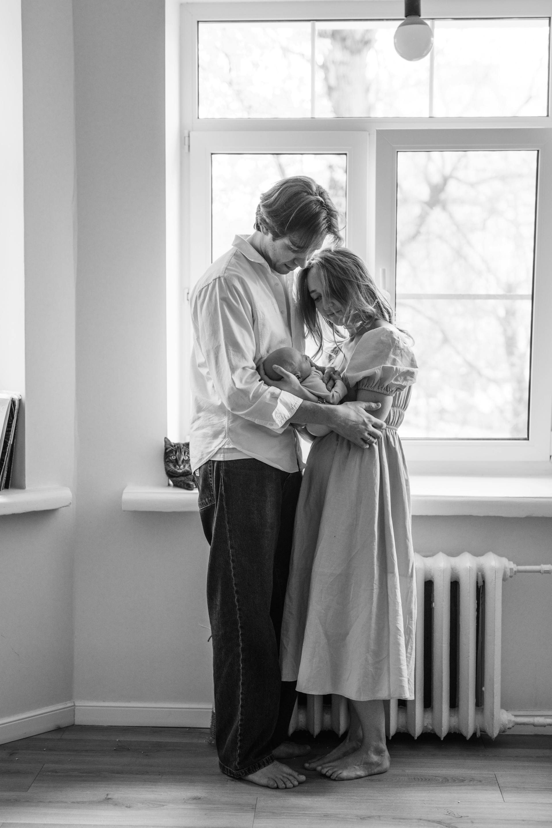 Grayscale photo of a couple holding a newborn baby | Source: Pexels