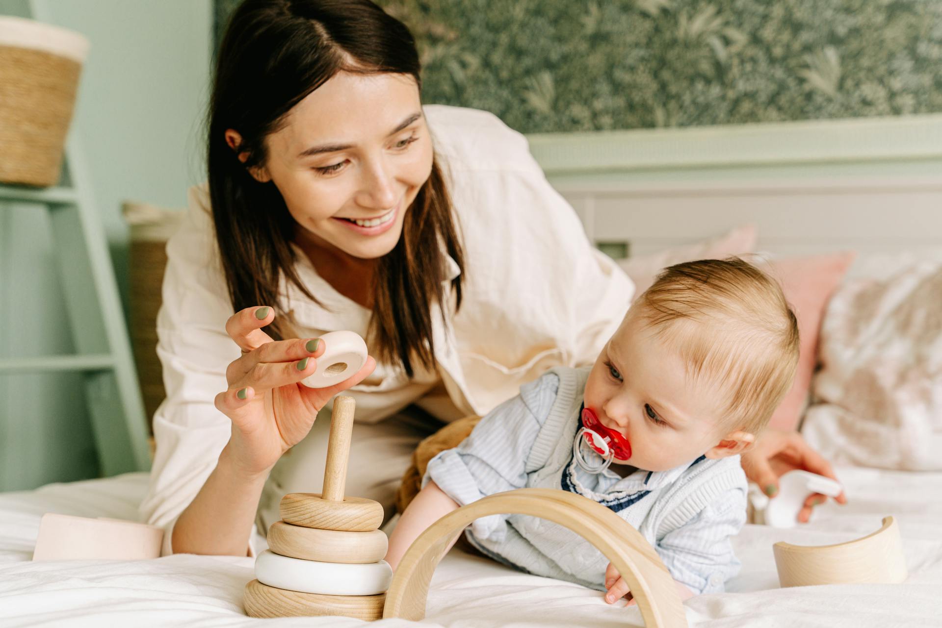A woman playing with her baby on a bed | Source: Pexels