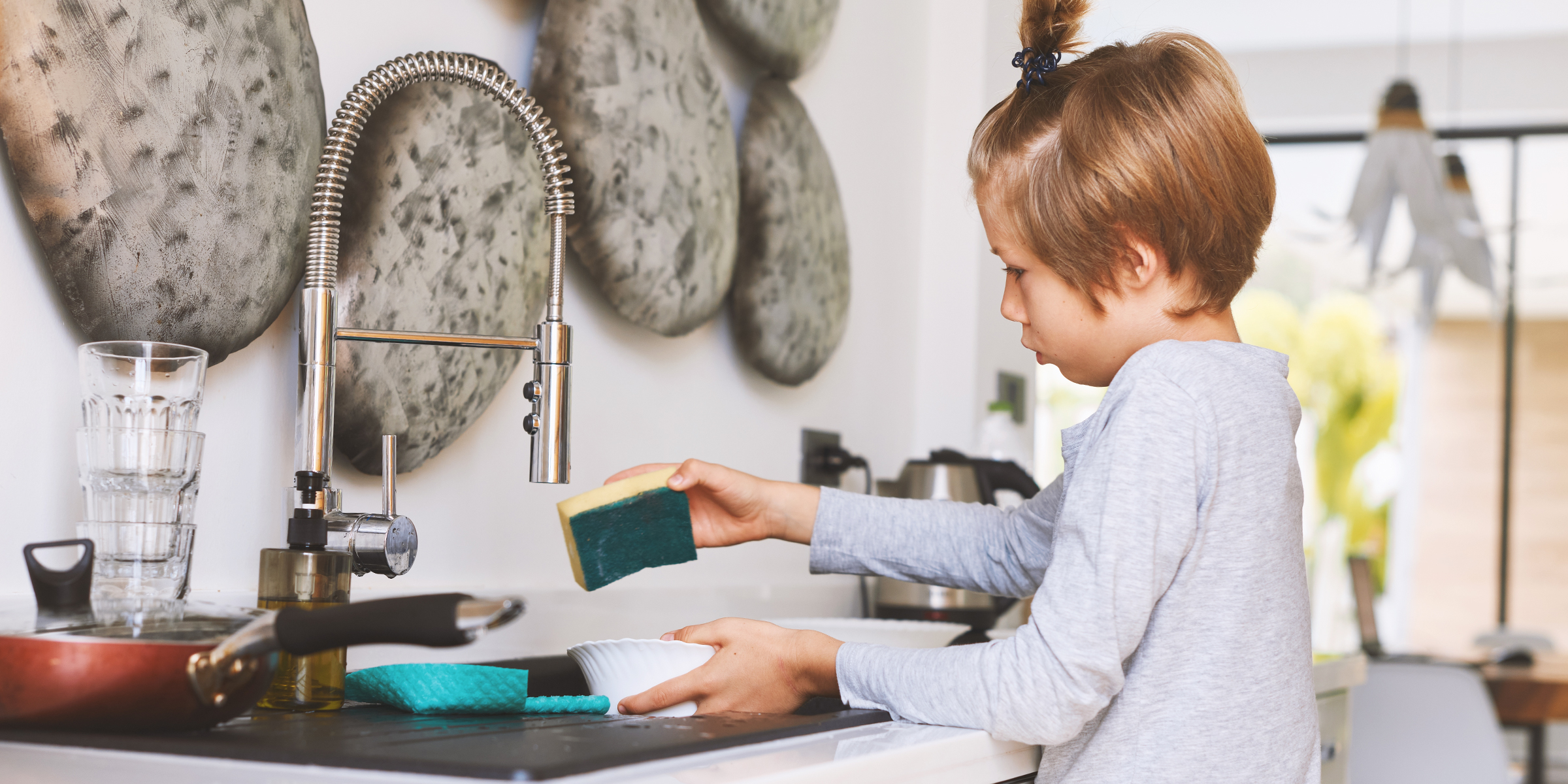 A child washing dishes | Source: Shutterstock
