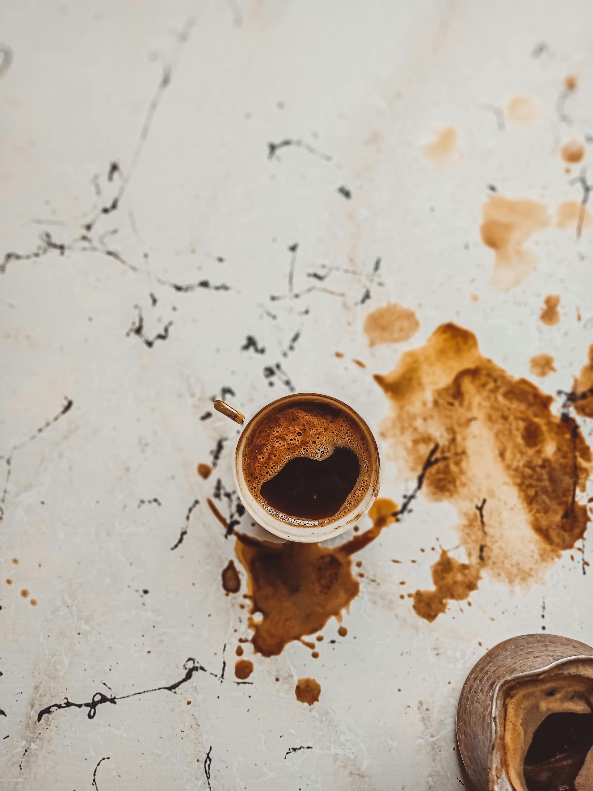 A cup of coffee with coffee spilled around it | Source: Pexels
