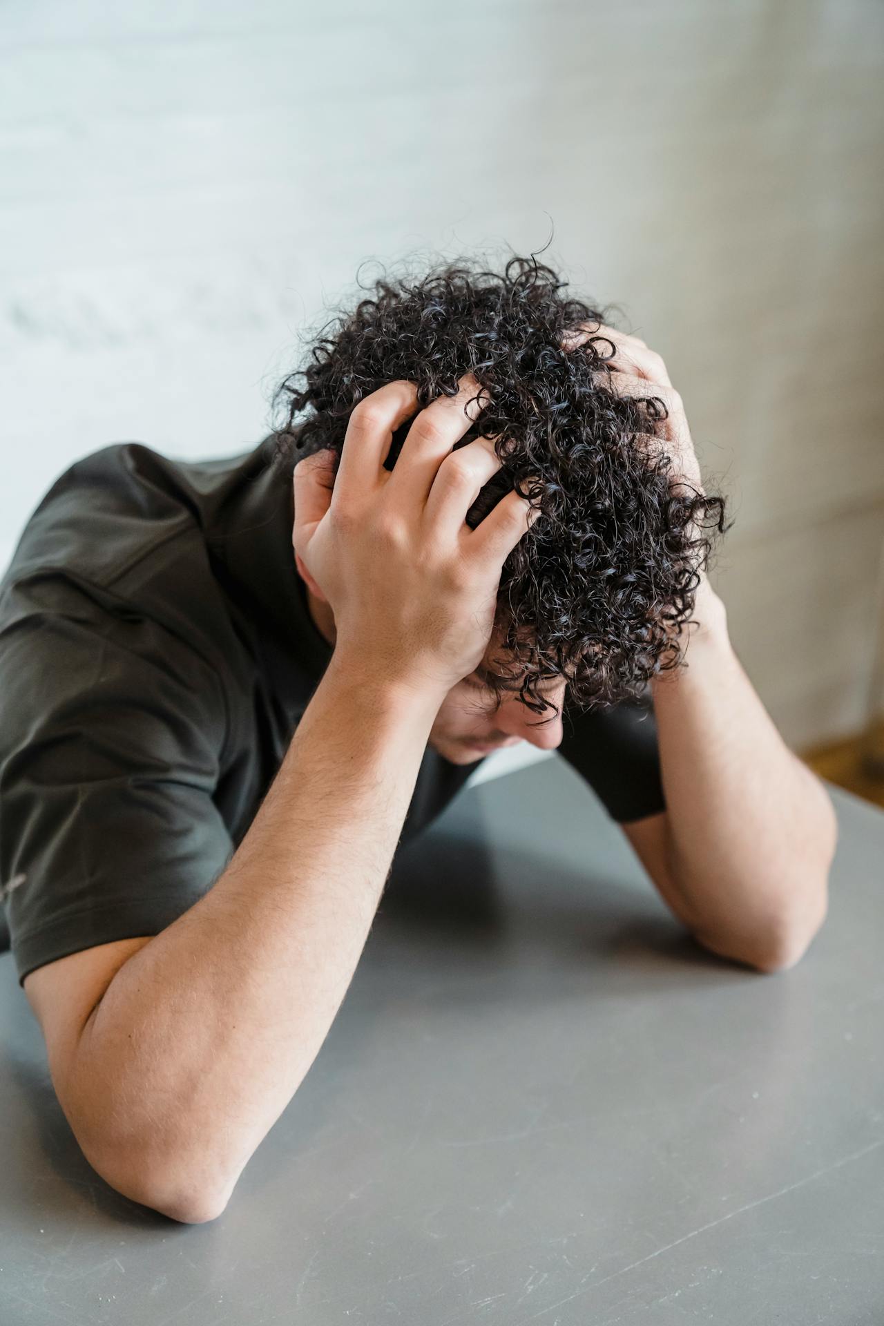 A stressed man seated at a table | Source: Pexels
