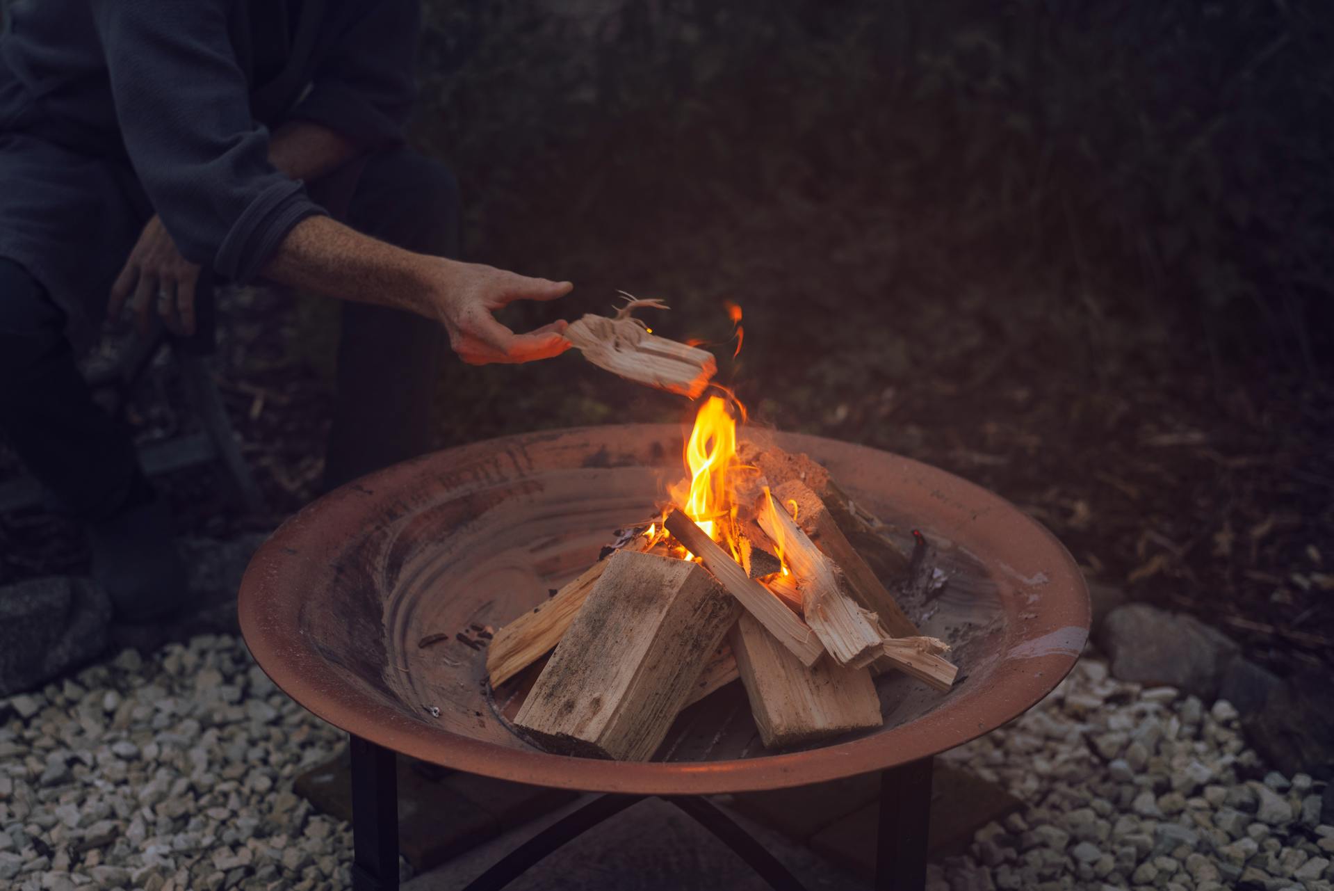 A man lighting a fire pit | Source: Pexels