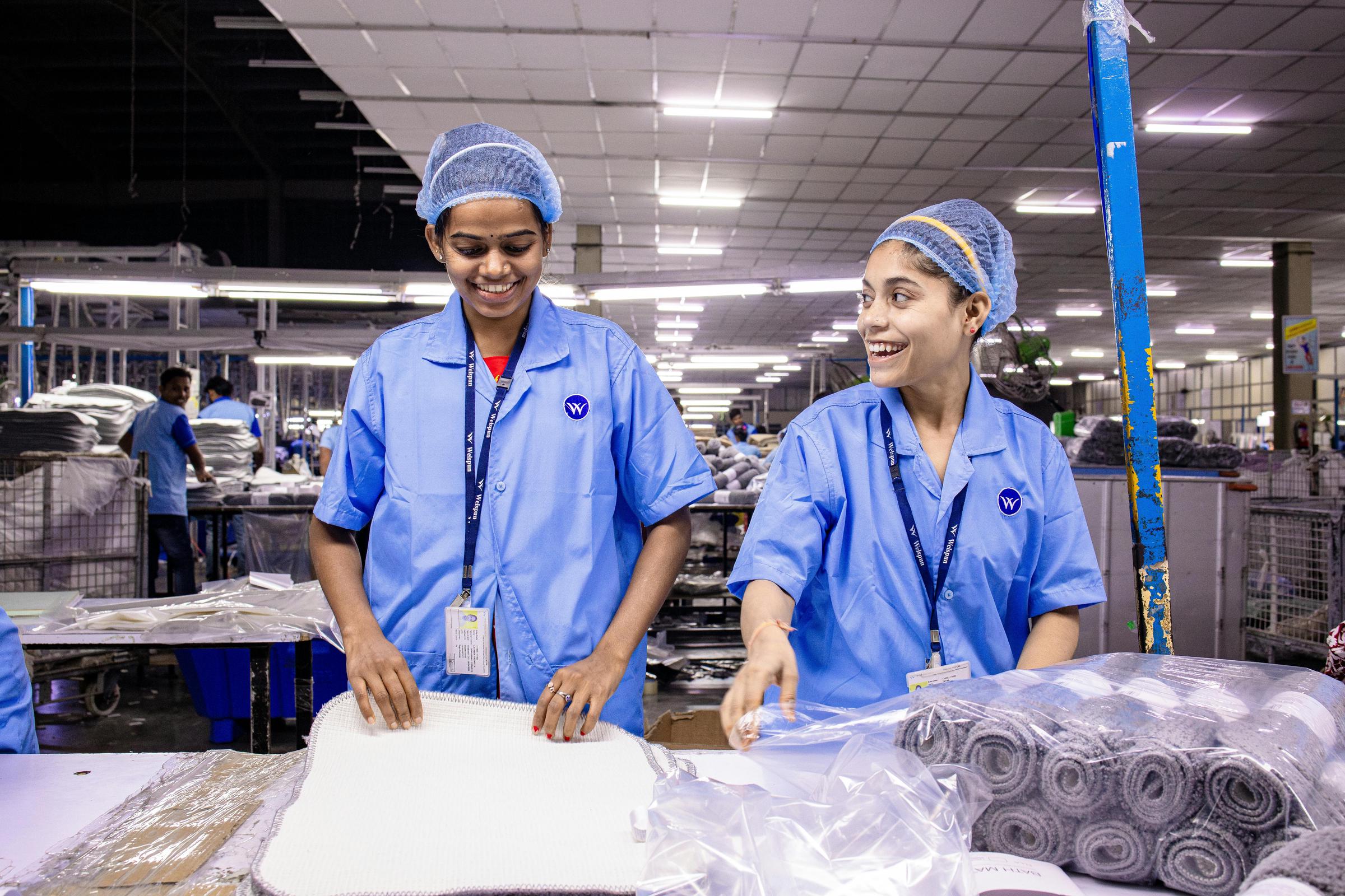 Happy employees working in a textile warehouse | Source: Pexels