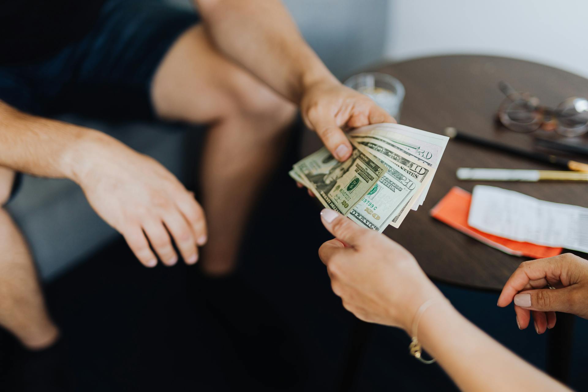 A man giving a woman money | Source: Pexels