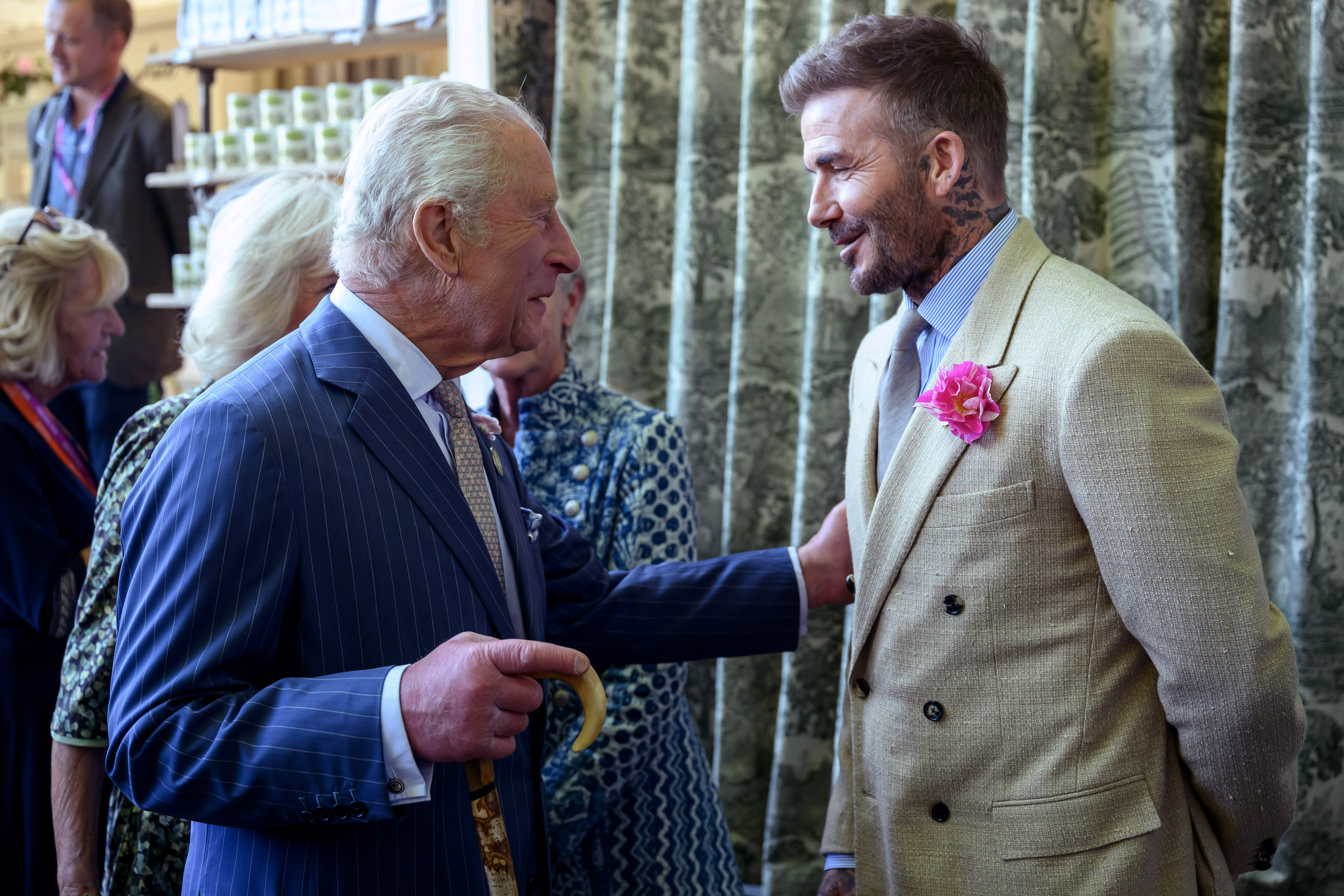 David Beckham, wearing a David Austin Roses "King's Rose," speaks with King Charles III, patron of the Royal Horticultural Society during a visit to the RHS Chelsea Flower Show at Royal Hospital Chelsea on May 20, 2025, in London, England. | Source: Getty Images