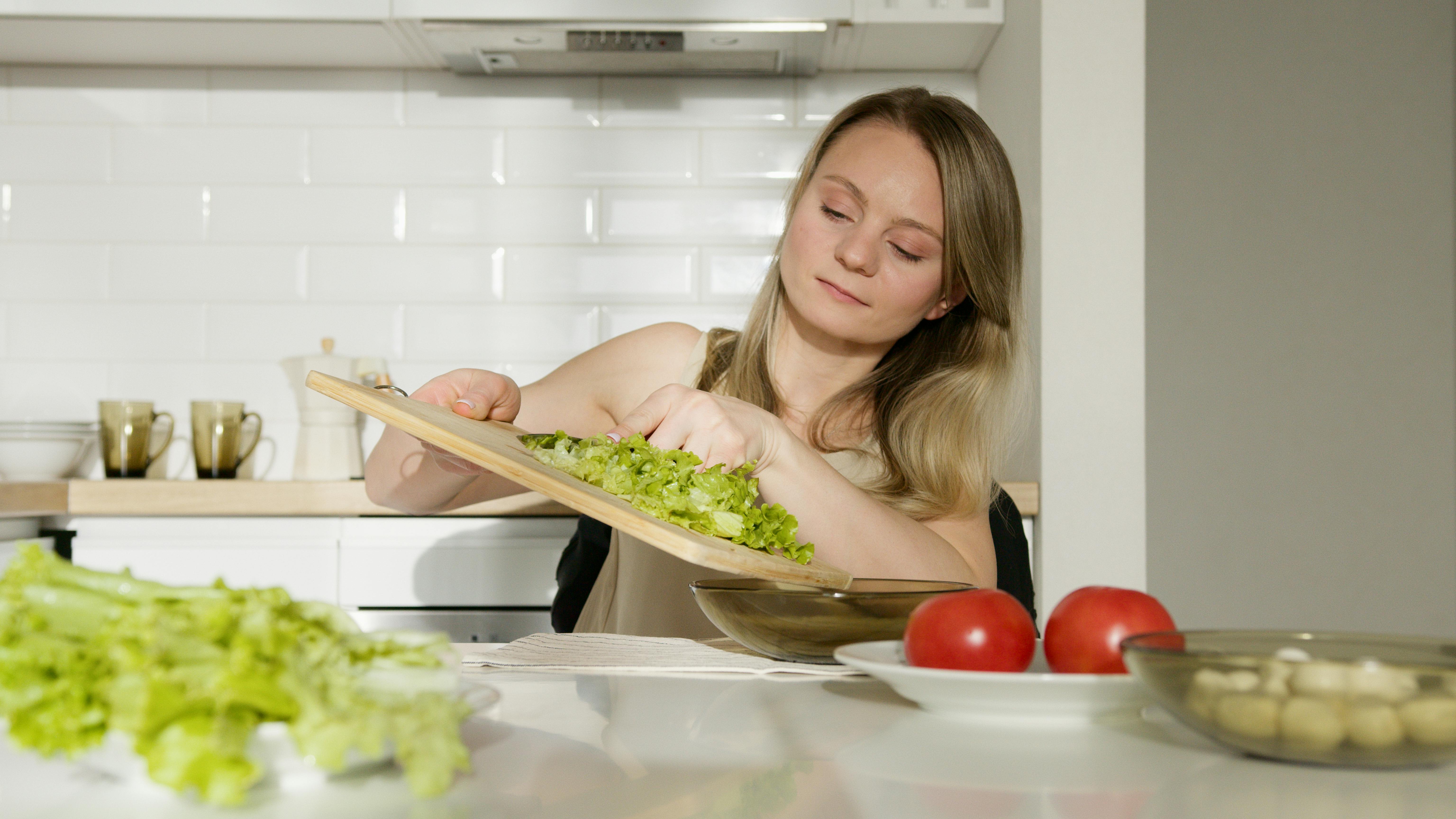 Young woman making salad | Source: Pexels