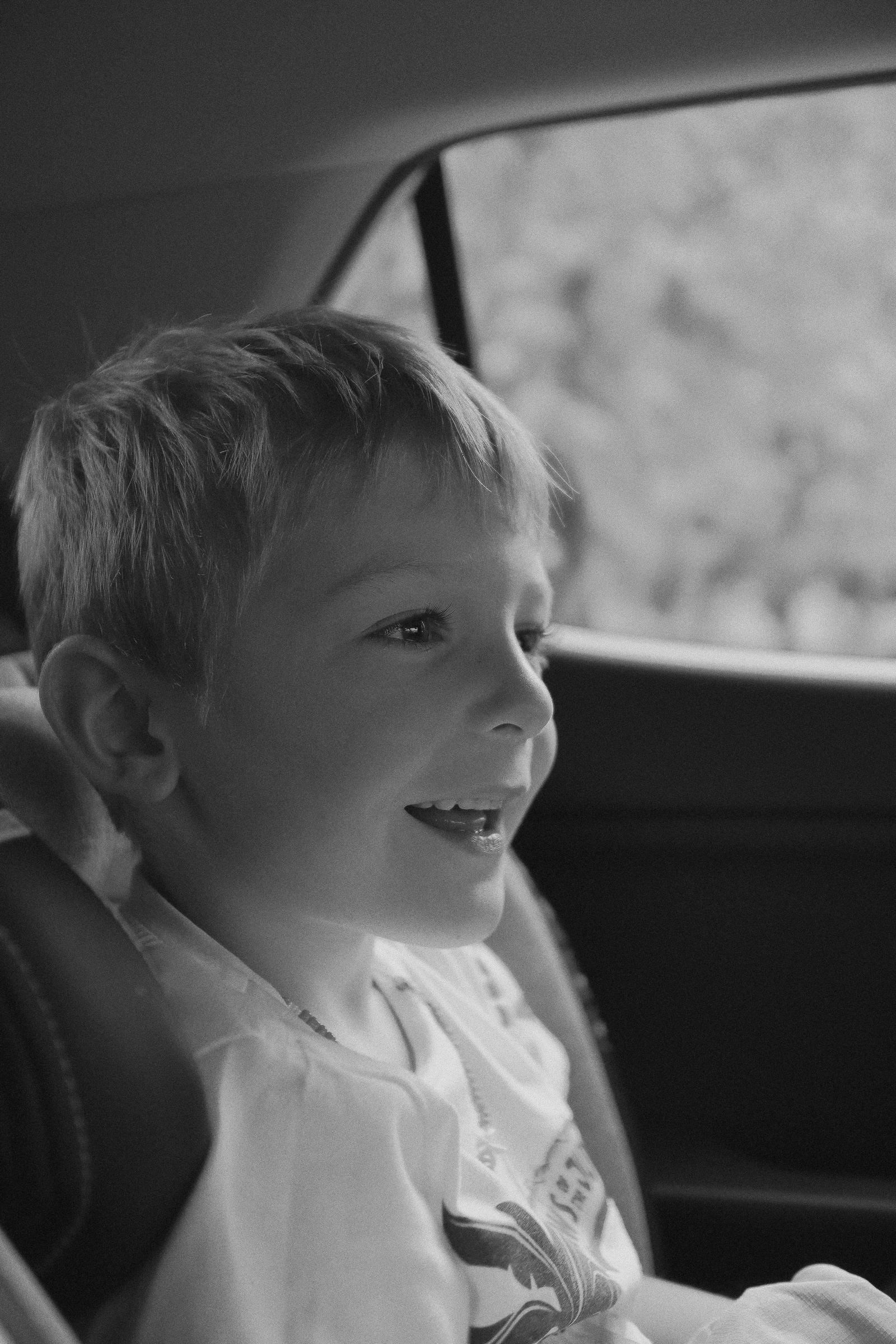 A happy boy in the backseat of a car | Source: Pexels