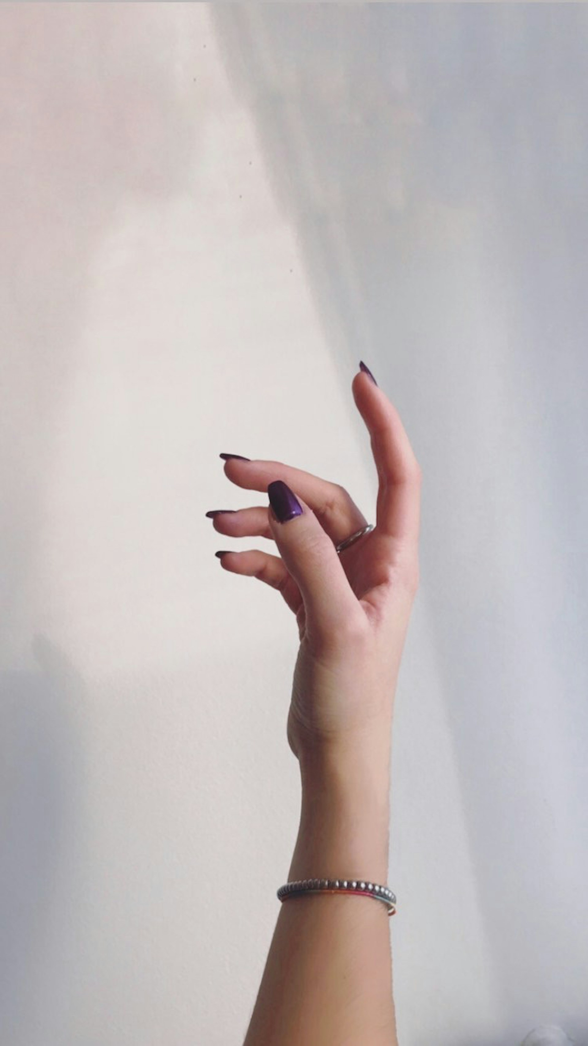 A woman's hand reaching toward a wall | Source: Unsplash