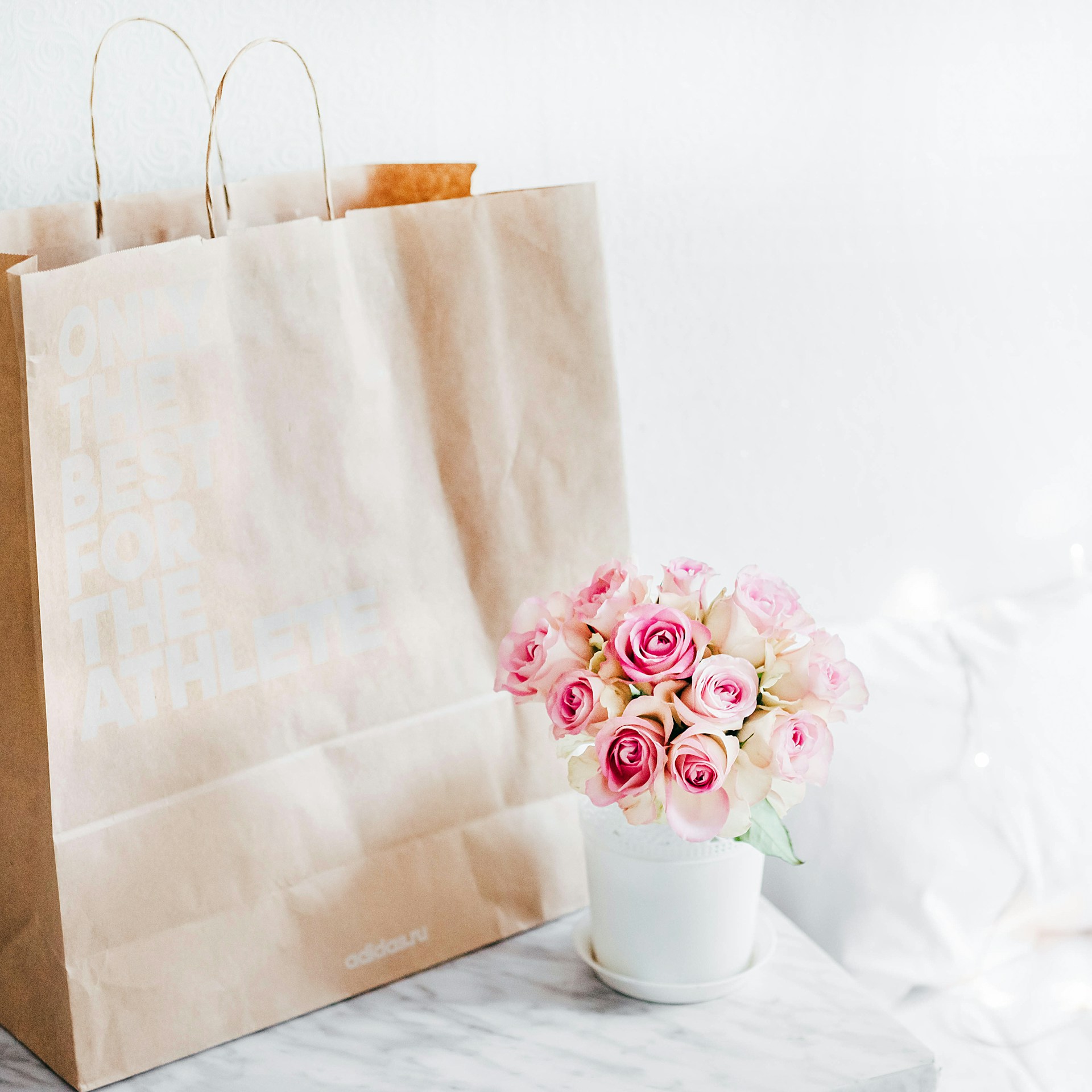 A paper bag beside a vase of roses | Source: Unsplash