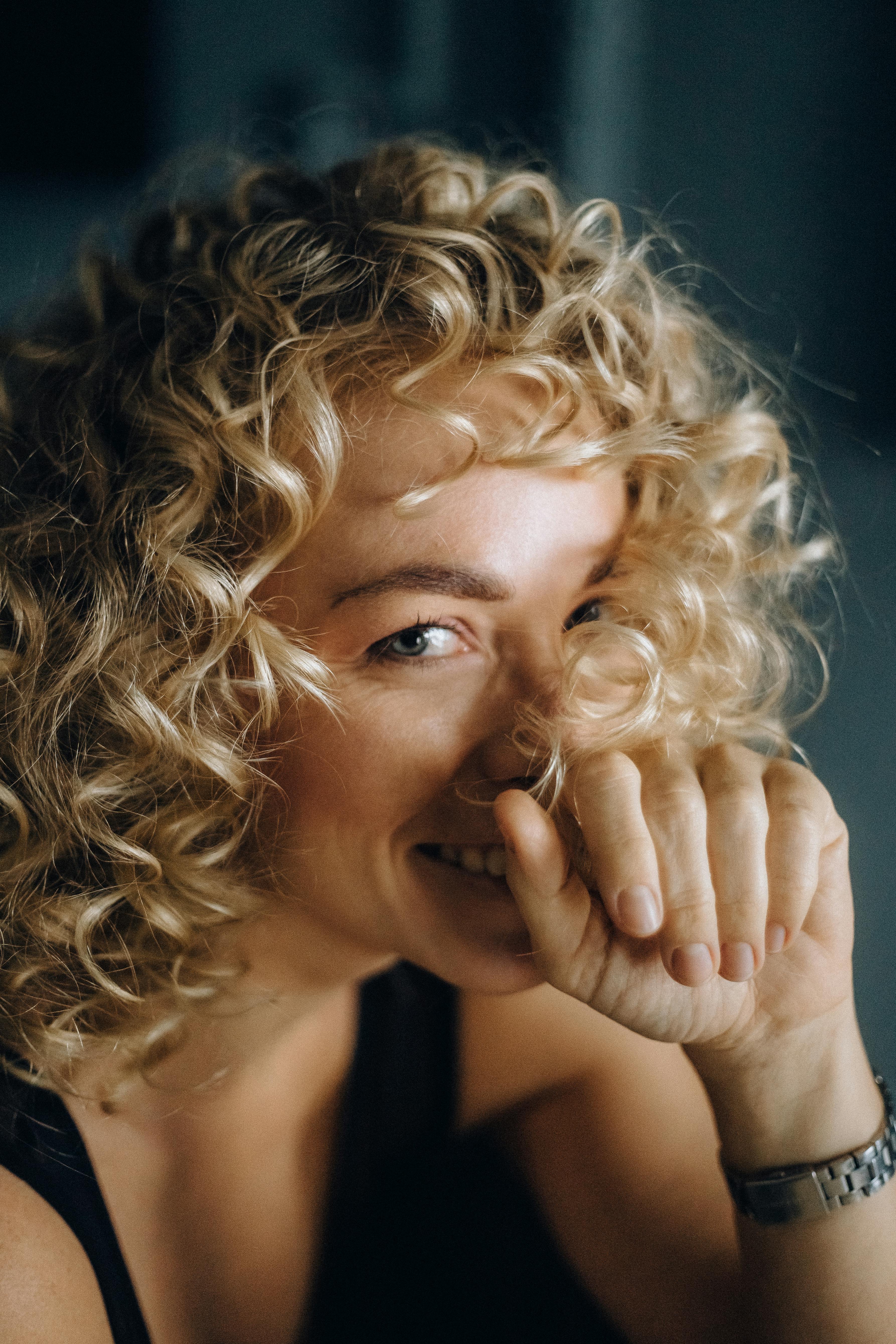 An amused woman with her hand on her face | Source: Pexels