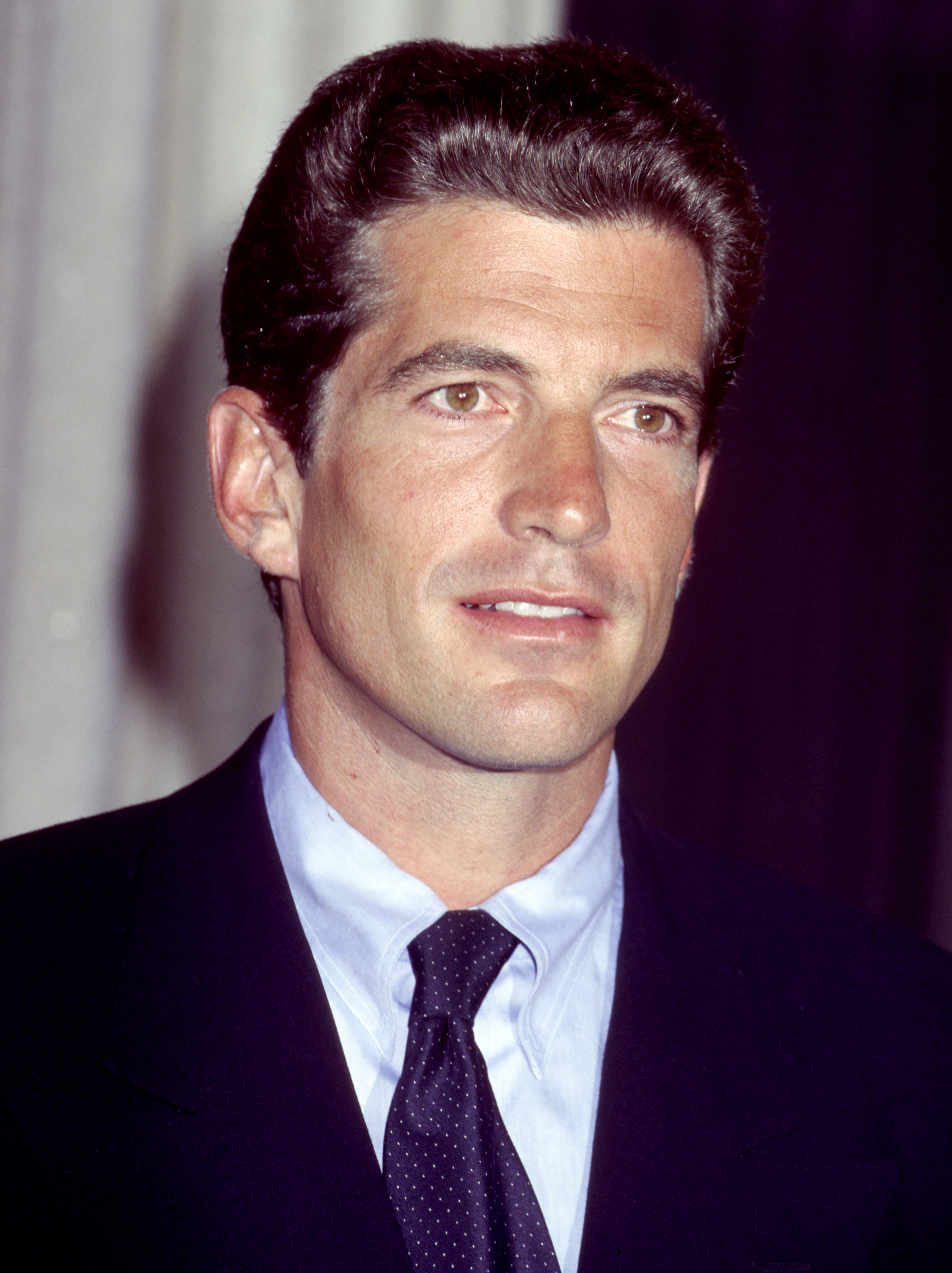 John F. Kennedy Jr. holds a press conference for his magazine, George, circa 1995. | Source: Getty Images