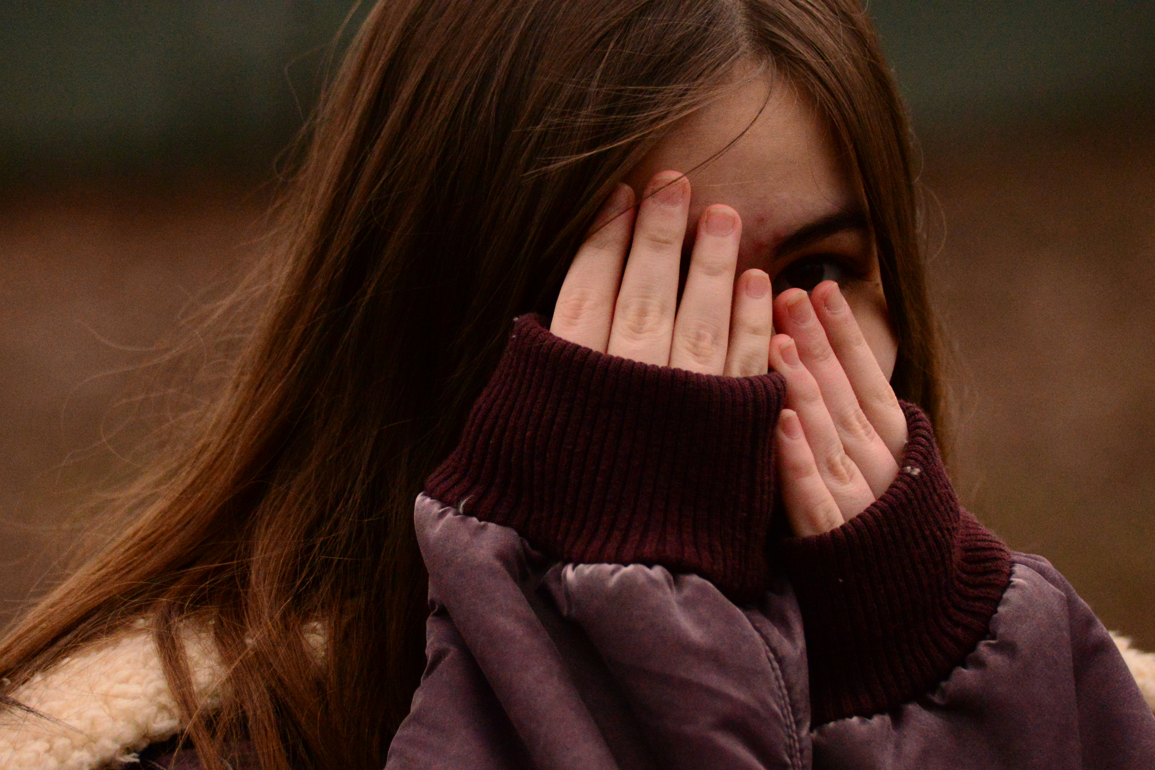 An upset girl covering her face | Source: Unsplash