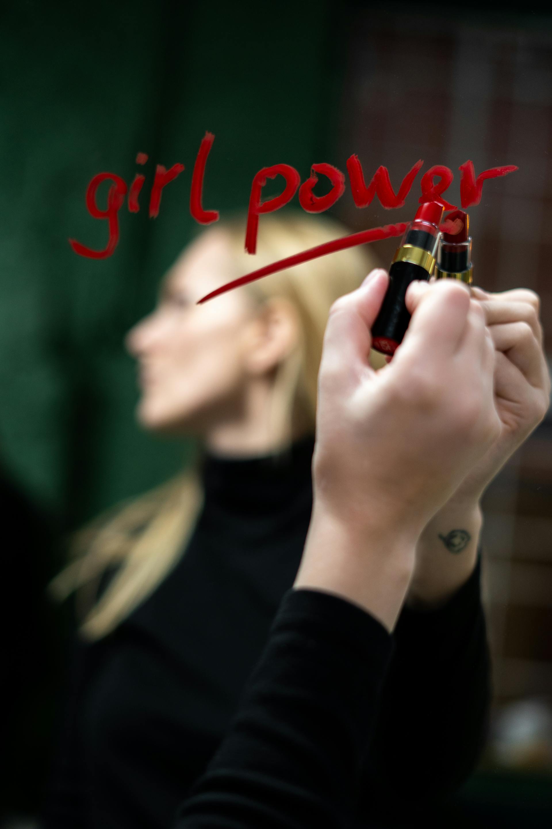 A woman writing on a mirror with red lipstick | Source: Pexels