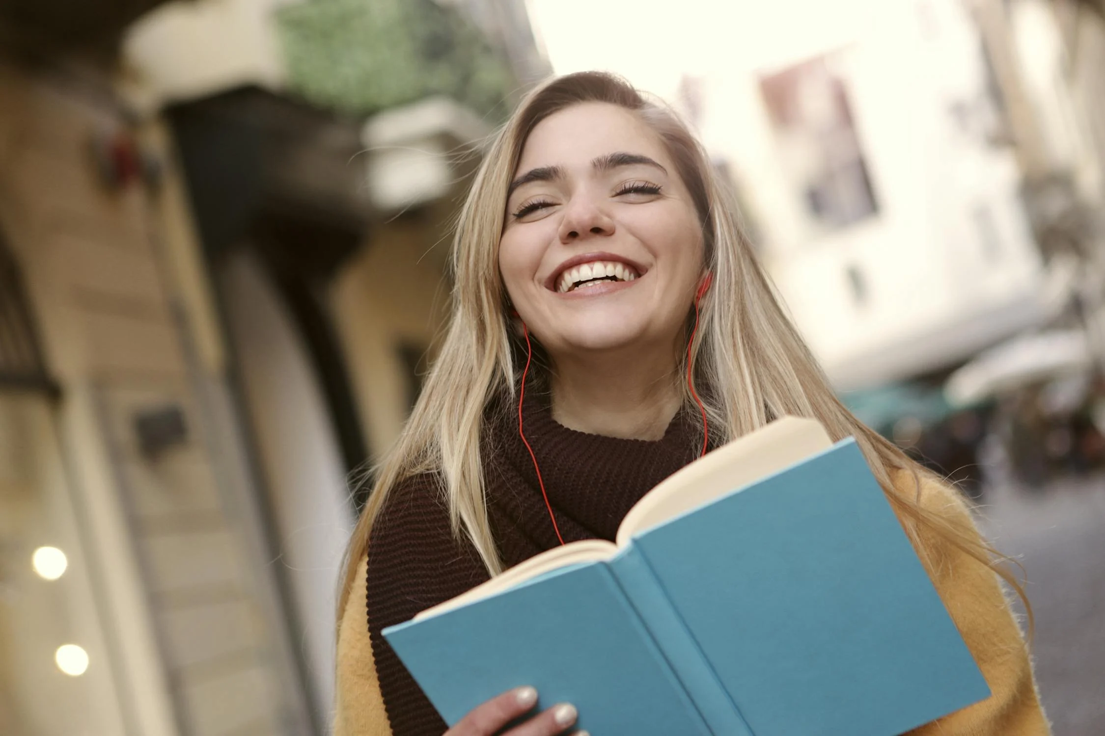 A smiling woman with a book | Source: Pexels