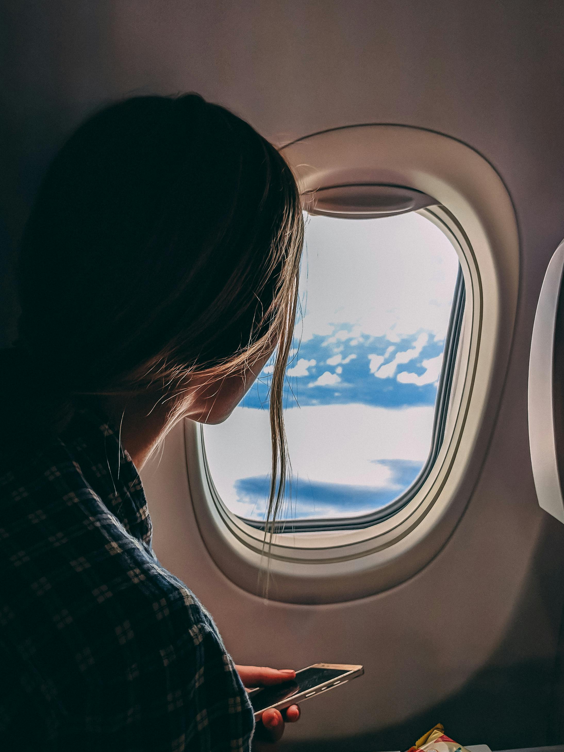 A woman looking out an airplane window | Source: Pexels