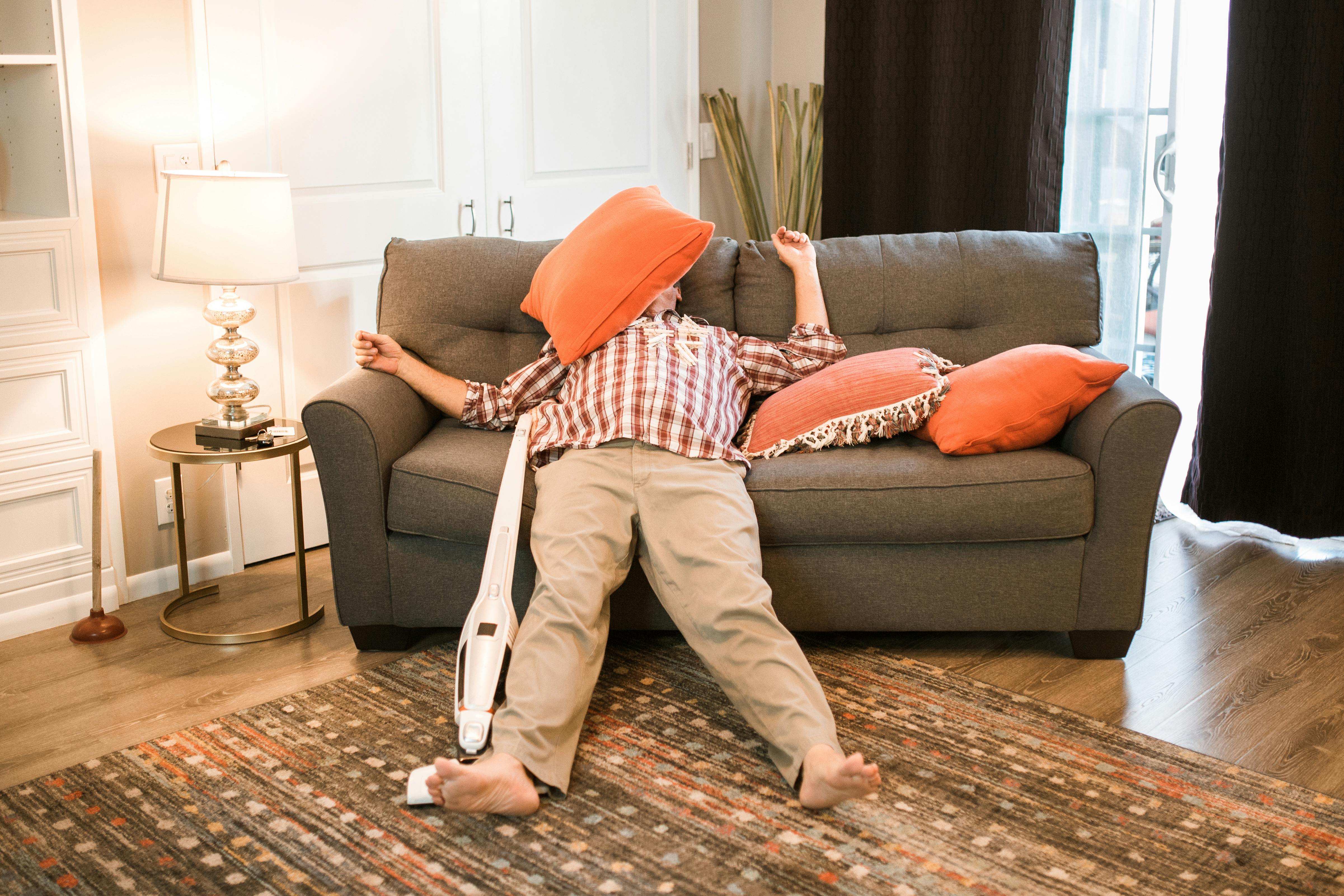 Tired man lying on a couch | Source: Pexels