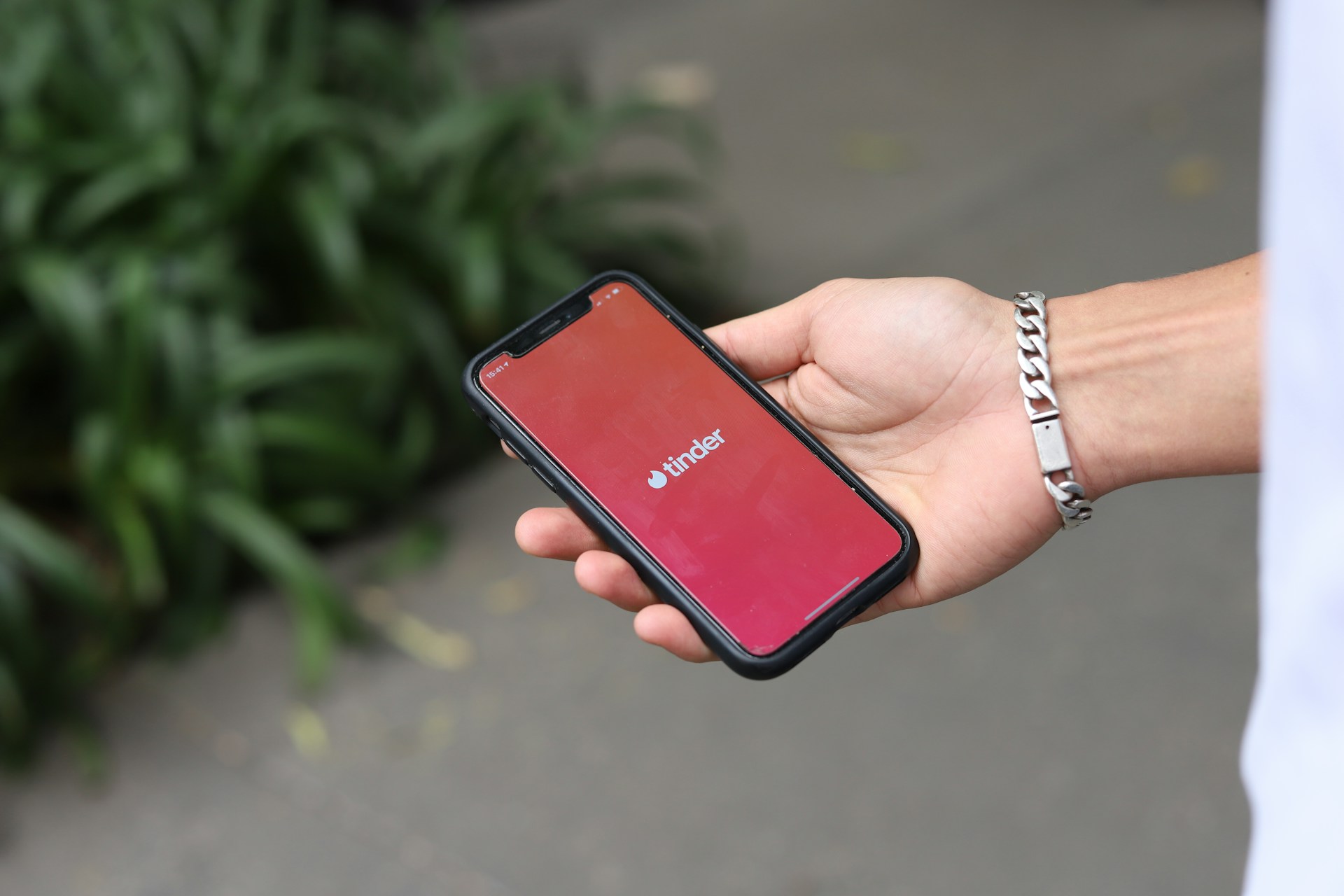 A man holding a cell phone displaying the Tinder app | Source: Unsplash