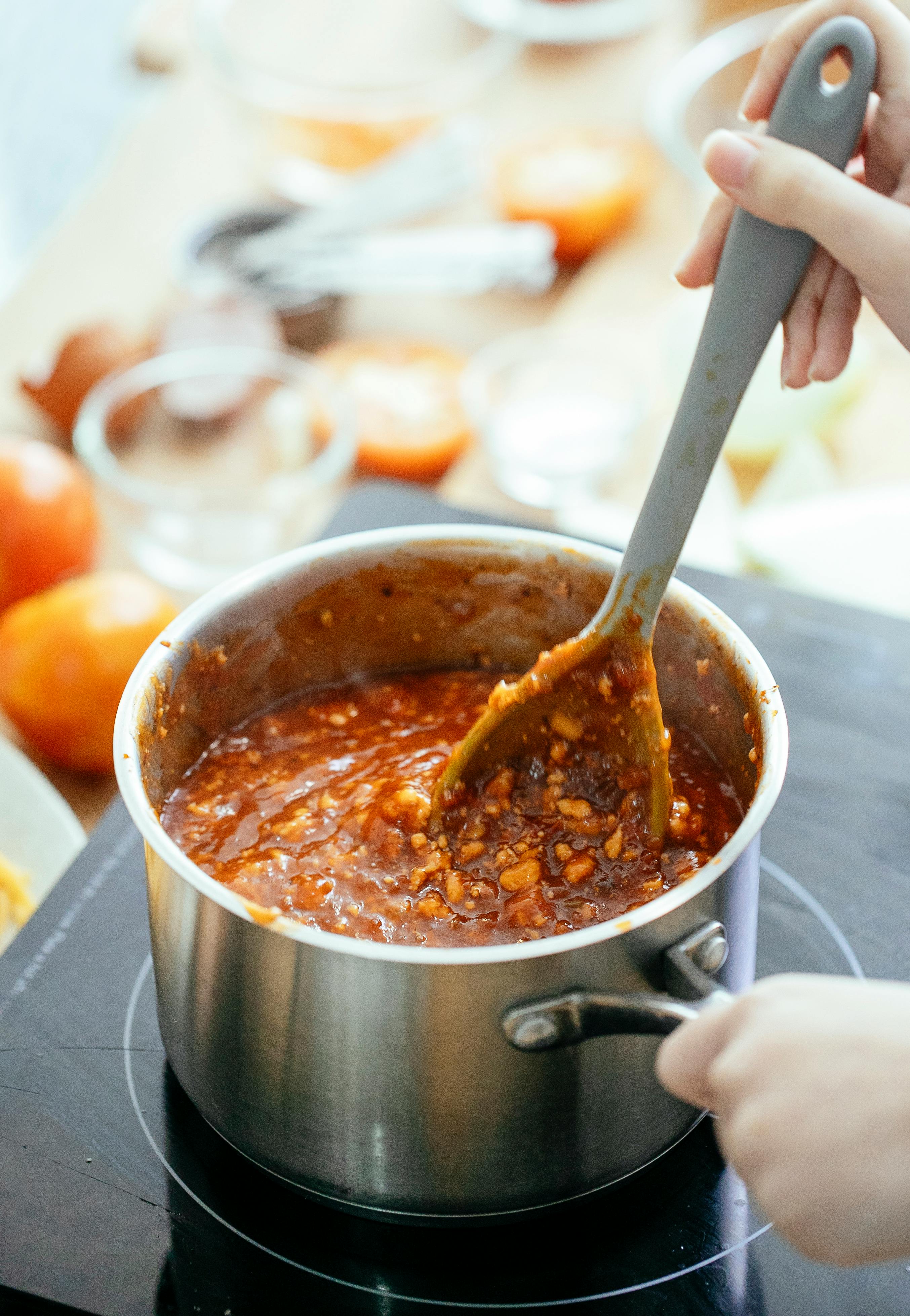 A person cooking a pot of chili | Source: Pexels