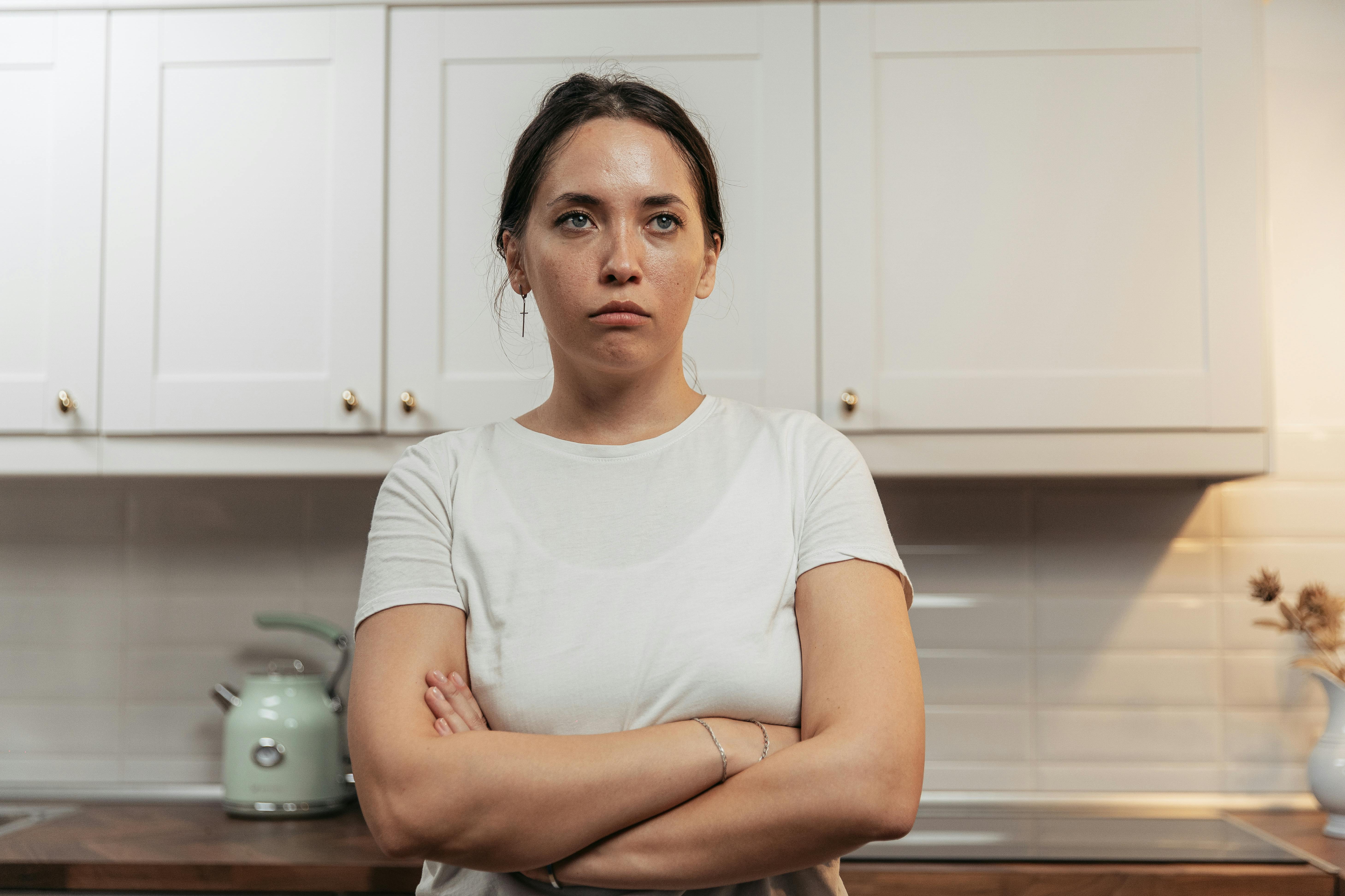 An upset woman standing with her arms folded | Source: Pexels