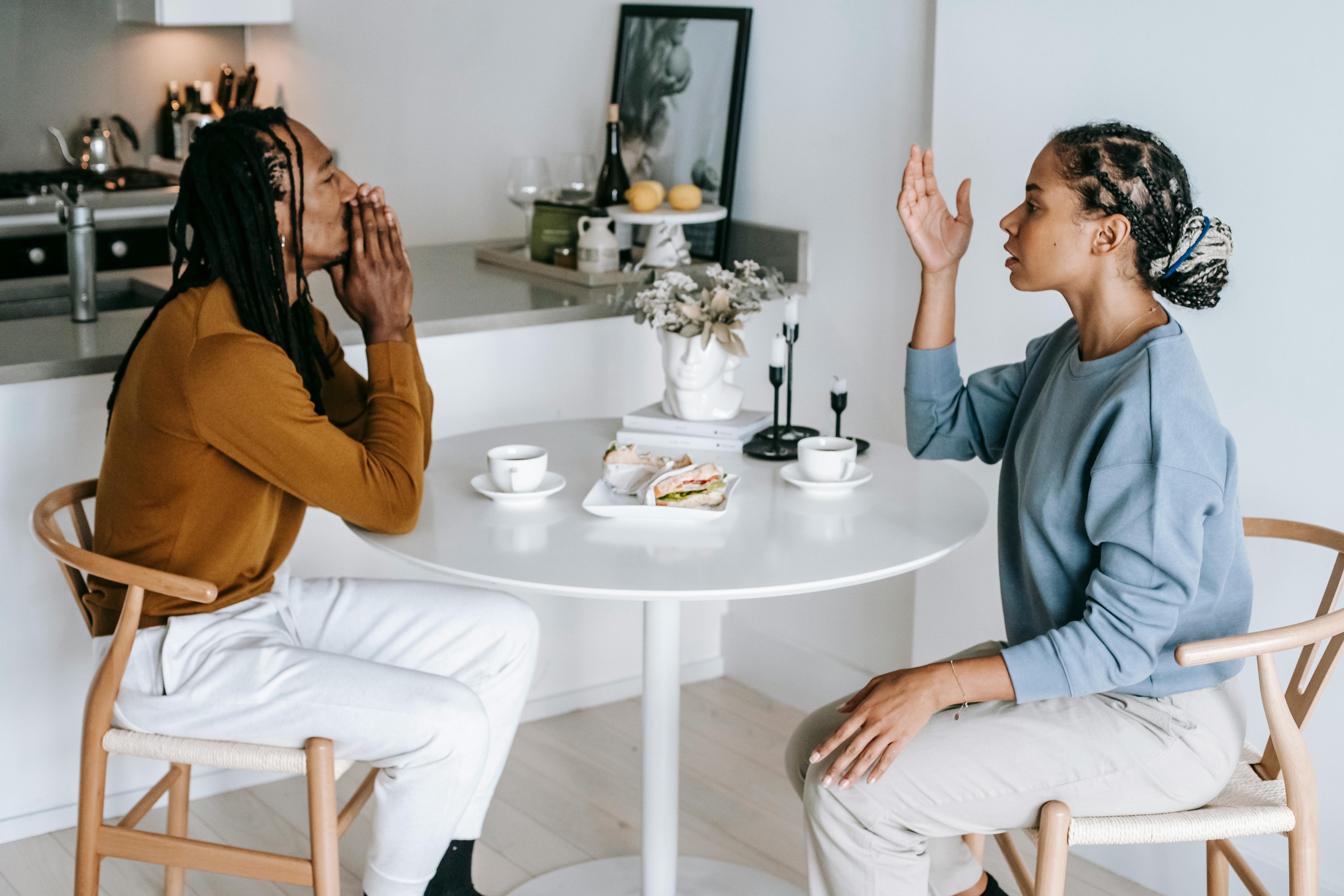 A couple having a conversation at a table | Source: Pexels