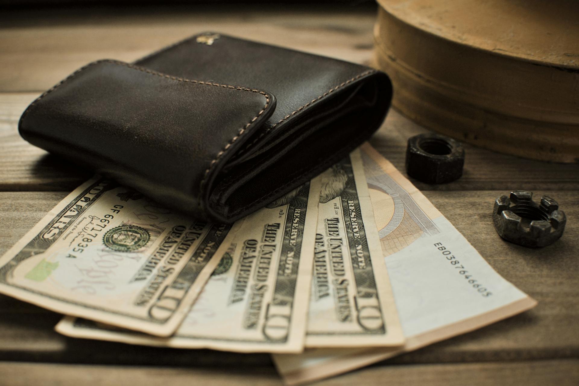 A wallet on top of dollar bills | Source: Pexels