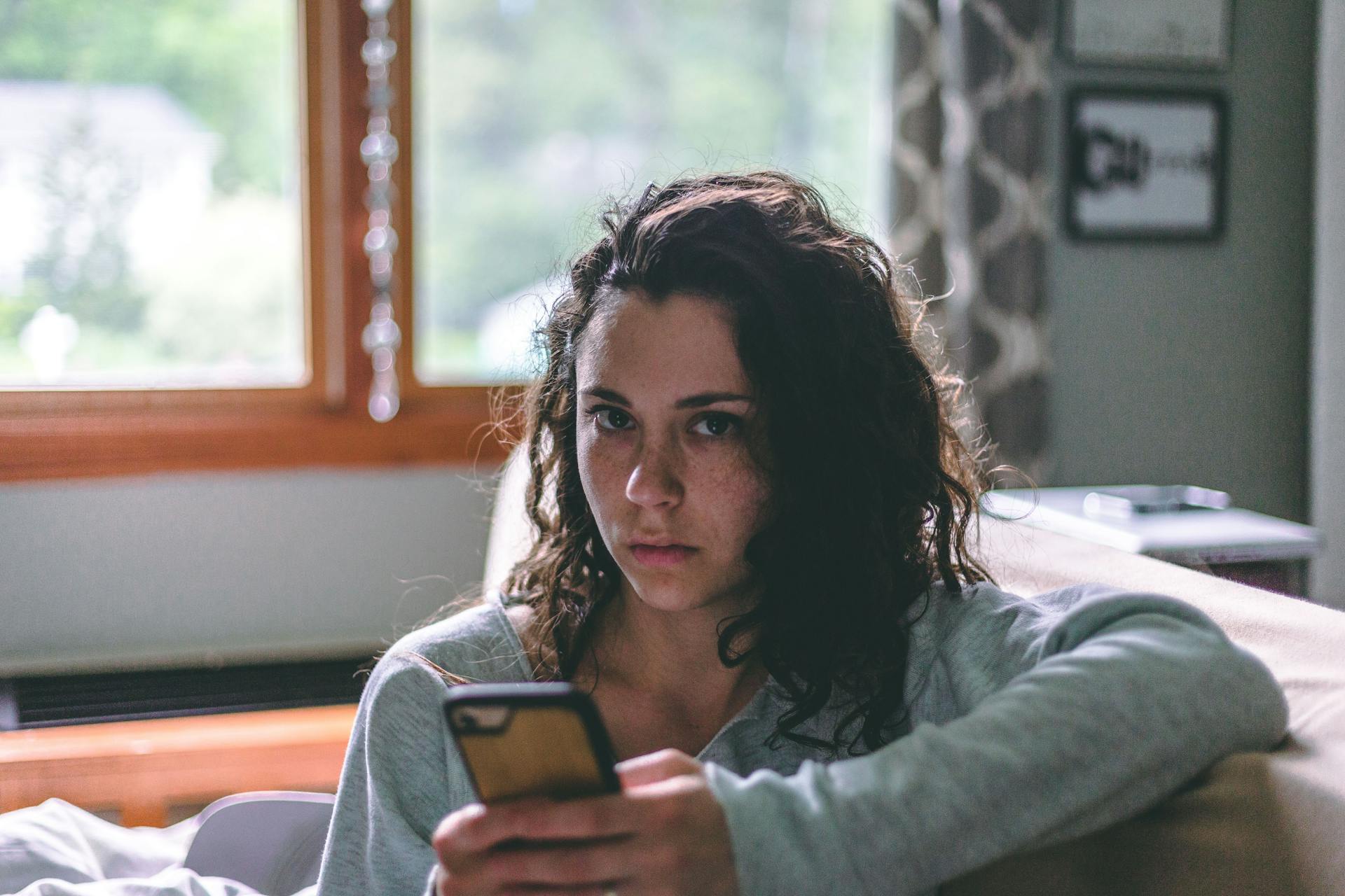 A woman holding a cell phone | Source: Pexels
