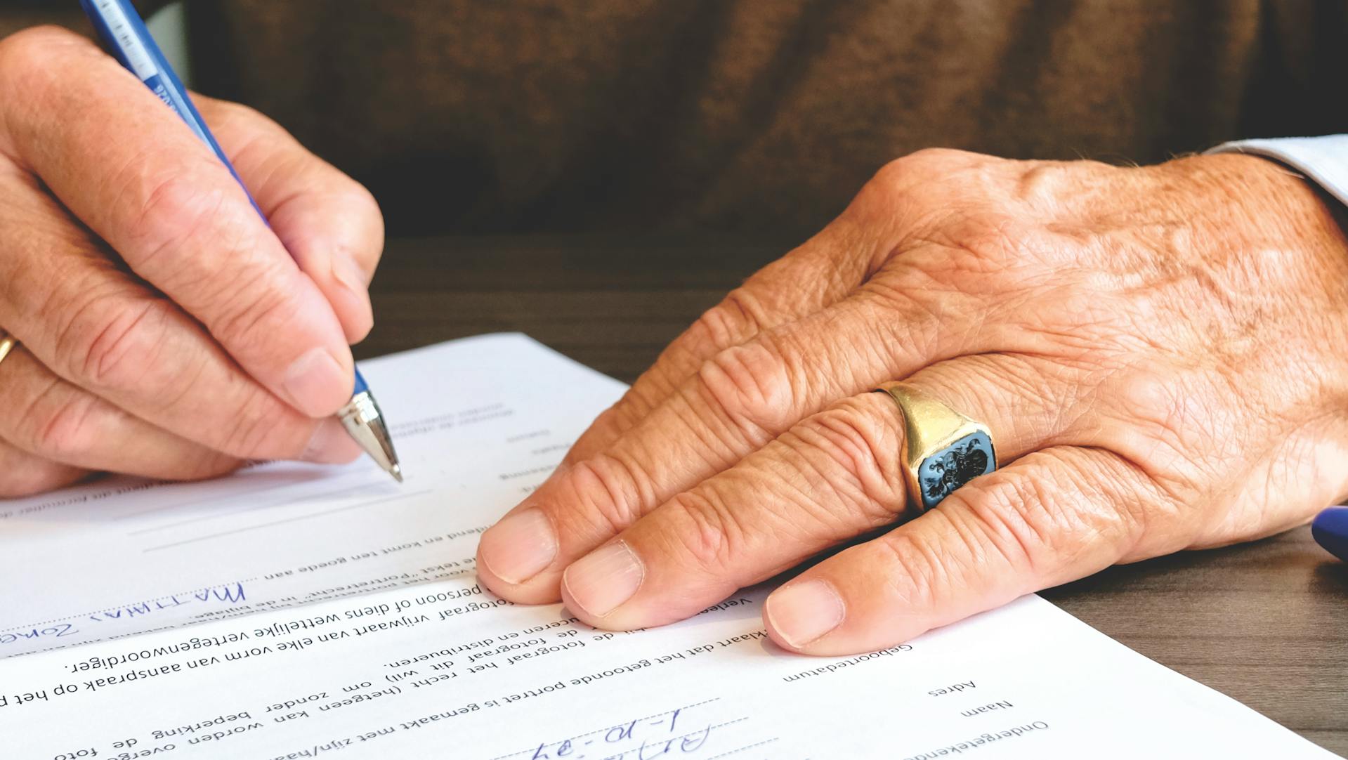 A close-up shot of a person signing a document | Source: Pexels