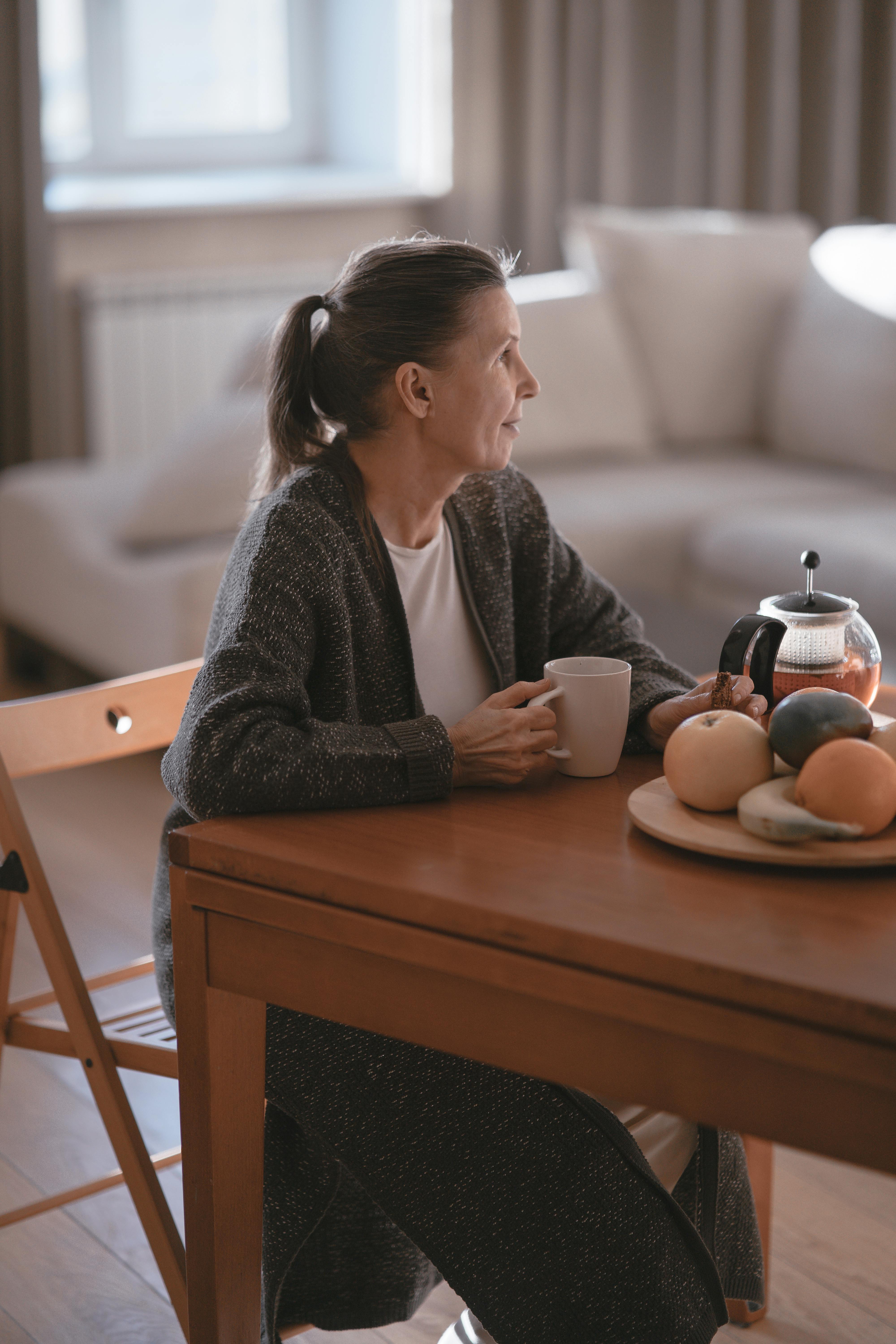 A woman sitting at a kitchen table | Source: Pexels