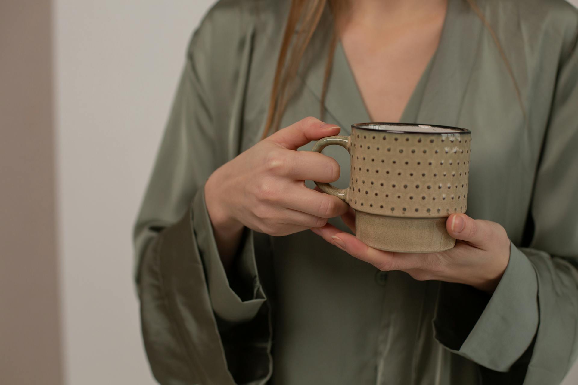 A woman holding a ceramic cup | Source: Pexels