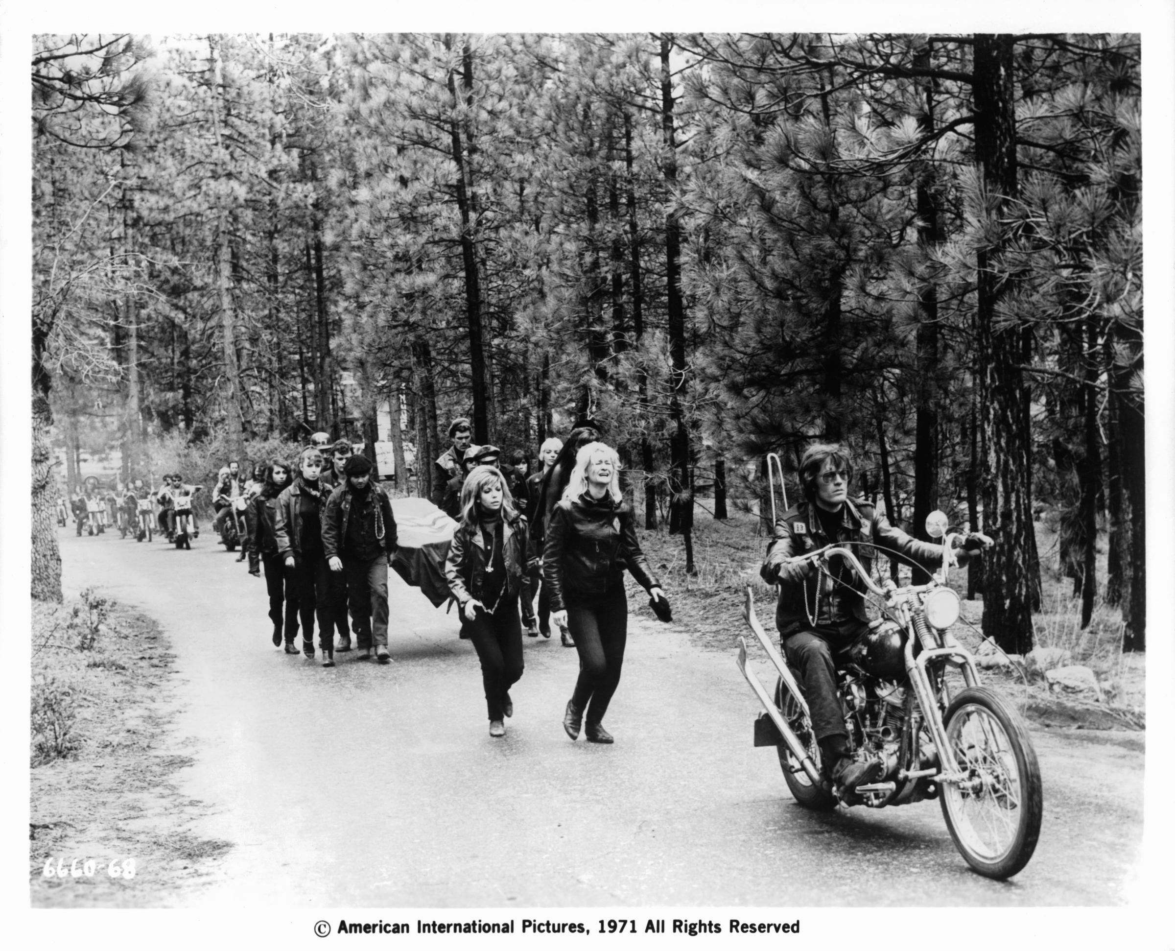 Nancy Sinatra, Diane Ladd and mourners following Peter Fonda on his bike a scene from the film "The Wild Angels," circa 1966.