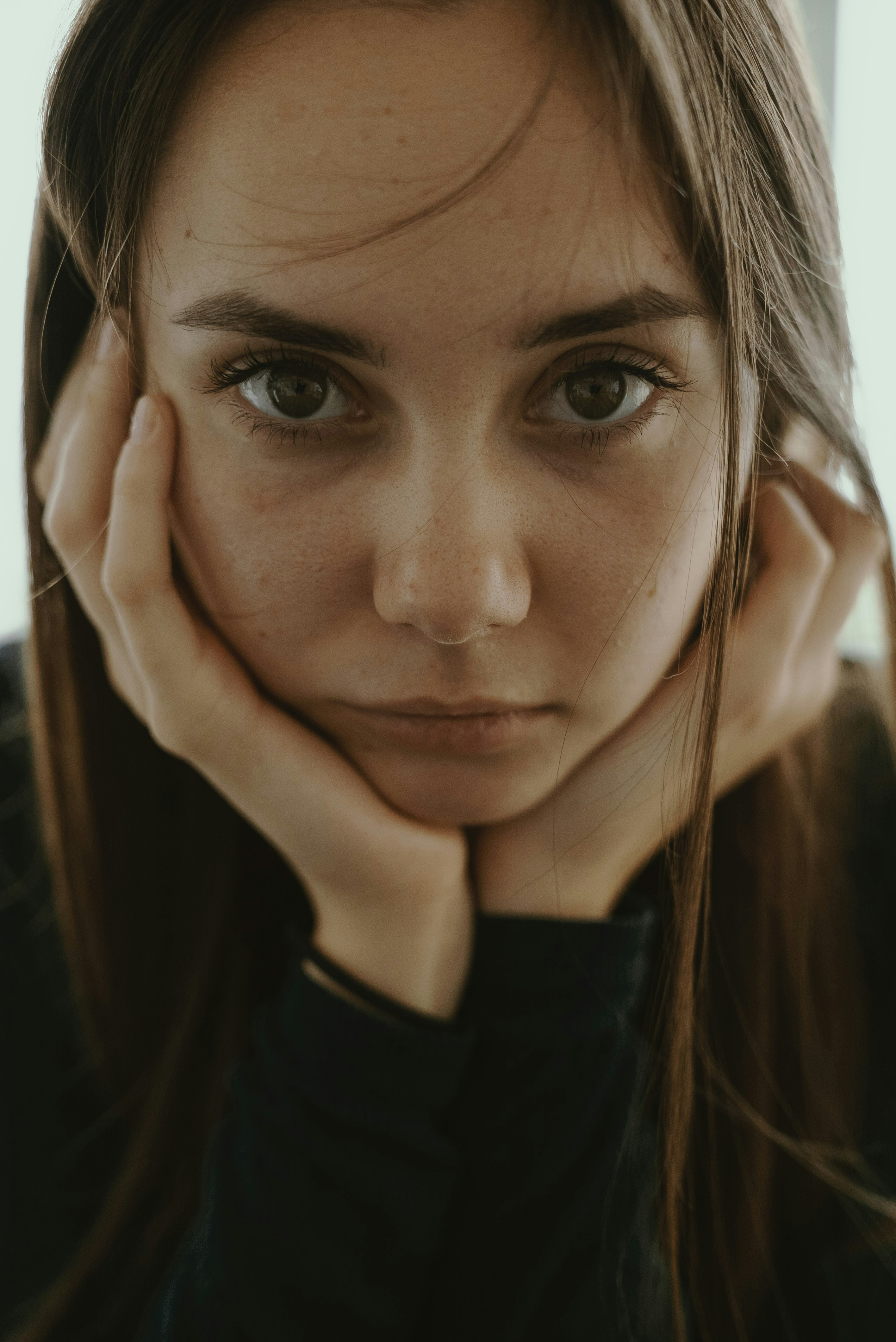 A pensive young woman with her head in her hands | Source: Unsplash