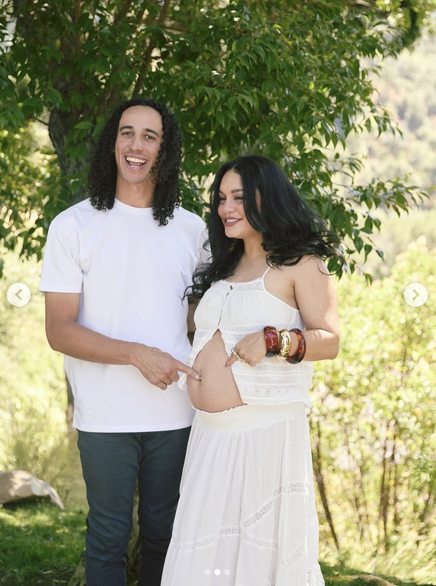 Cole Tucker playfully points at Vanessa Hudgens' belly button while posing for photos with her growing baby bump, posted on July 12, 2025 | Source: Instagram/vanessahudgens