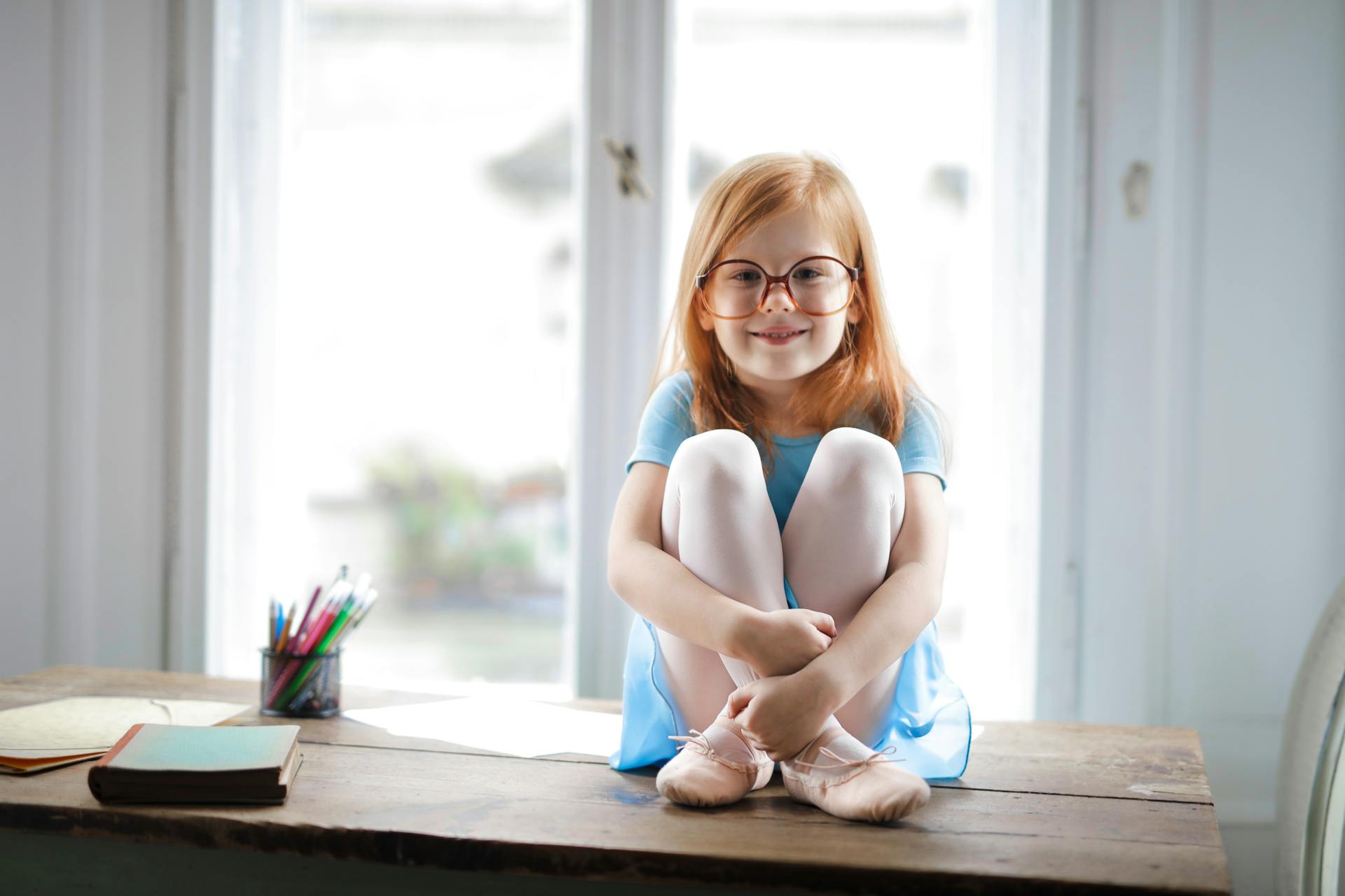 A little girl sitting on a table | Source: Pexels