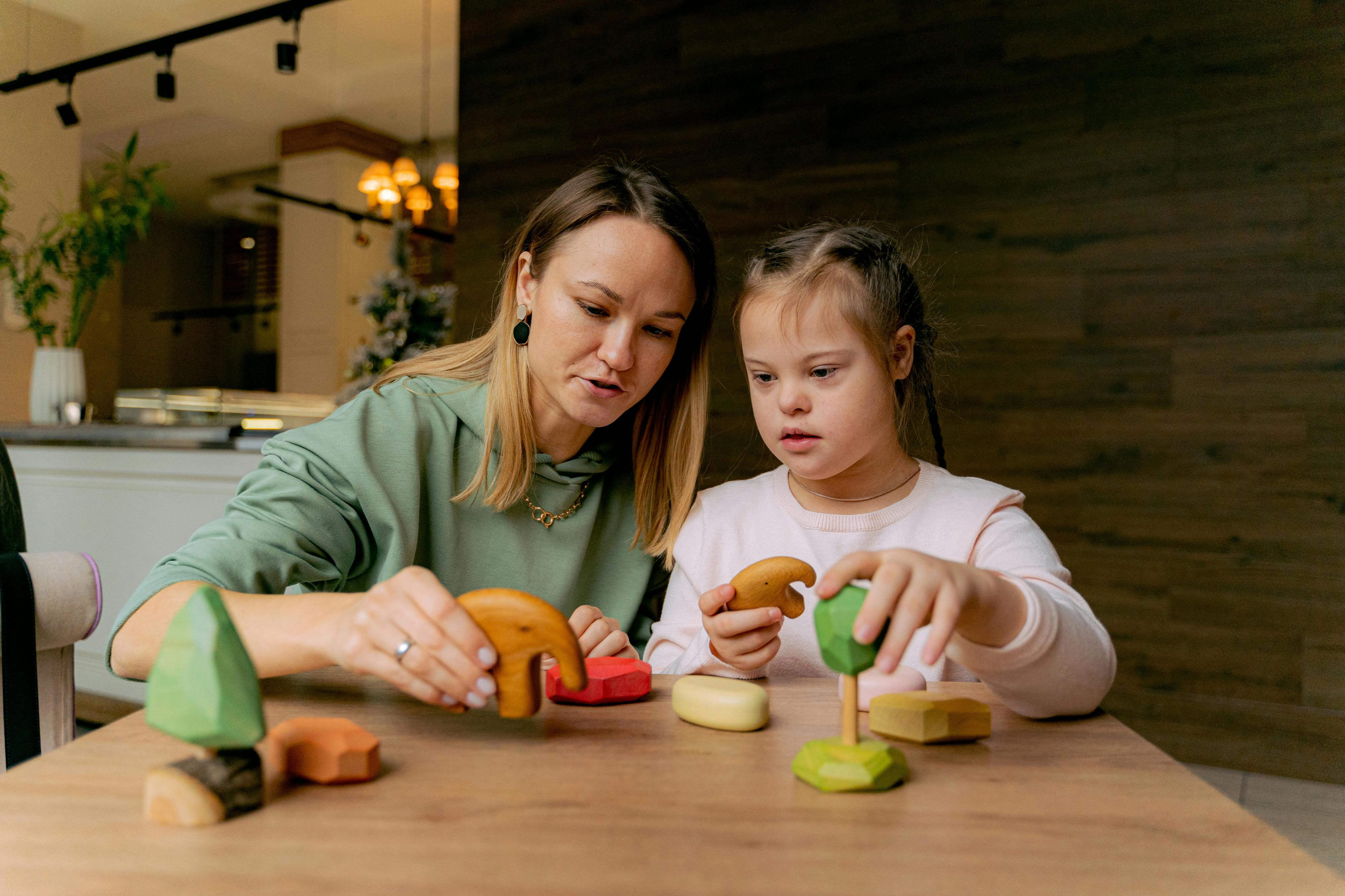 Mother bonding with her daughter as she plays with her toys | Source: Pexels