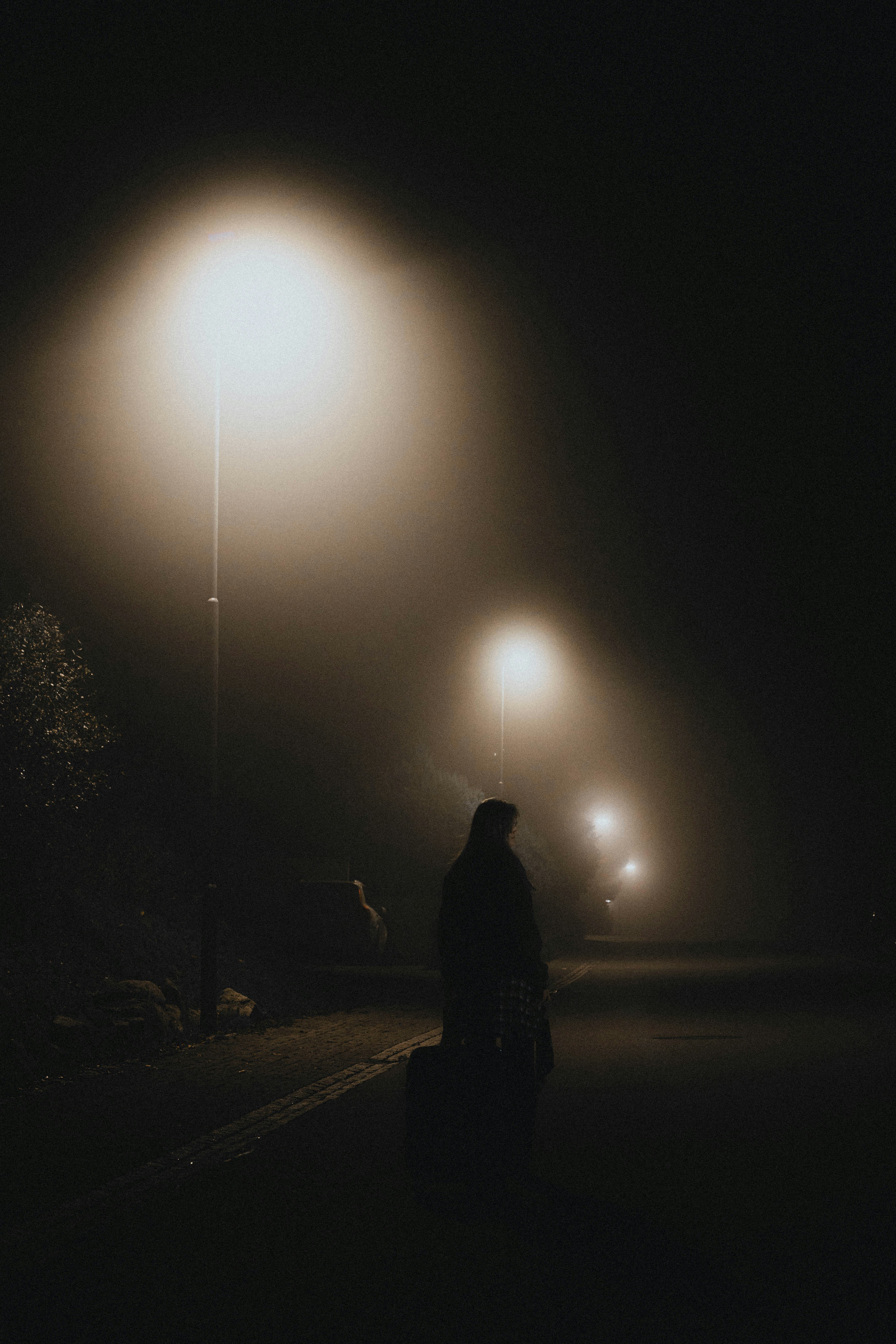 A woman standing in a street at night | Source: Unsplash